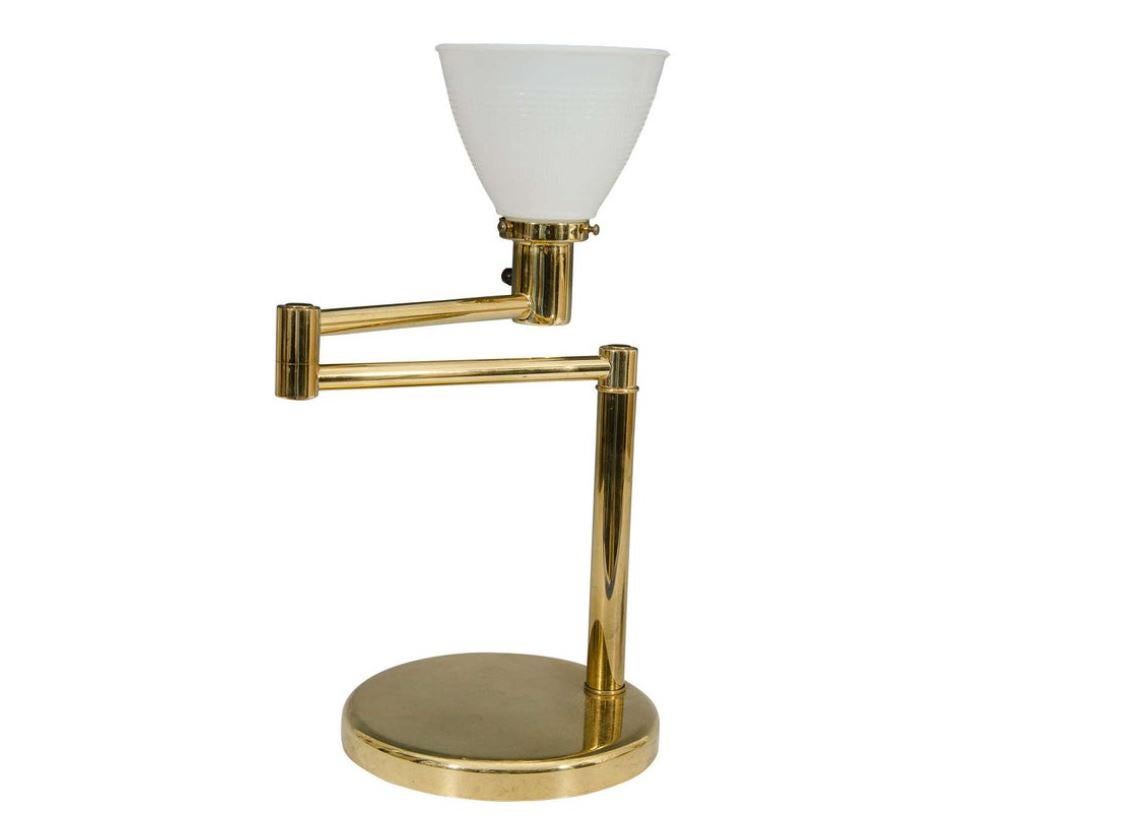 A chic 1970s Modern adjustable swing arm brass desk or table lamp with white milk glass shade. Lamp retains its original maker's mark tag as show in images #7 and 8. 'NESSEN LAMPS', designed by Walter Von Nessen.

Measures: 18.5 in. height x 5 in.