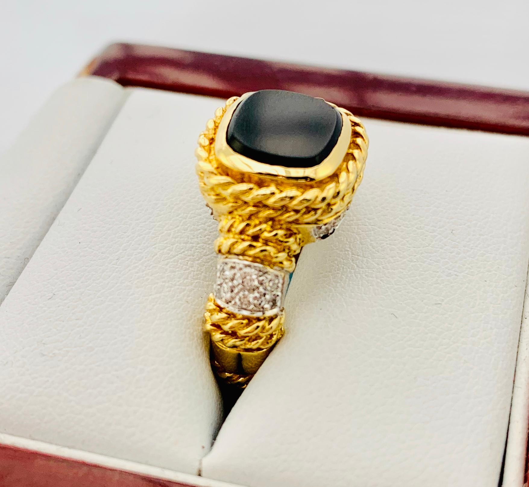 Gorgeous Cassis Designer Ring! This is made in 18K yellow Gold and has a 9 by 9mm center, bezel set black onyx stone and 22 Brilliant diamonds. The estimated carat weight of diamonds is 0.25, they are G-H in color and Vs clarity. Ring Size is 5.75