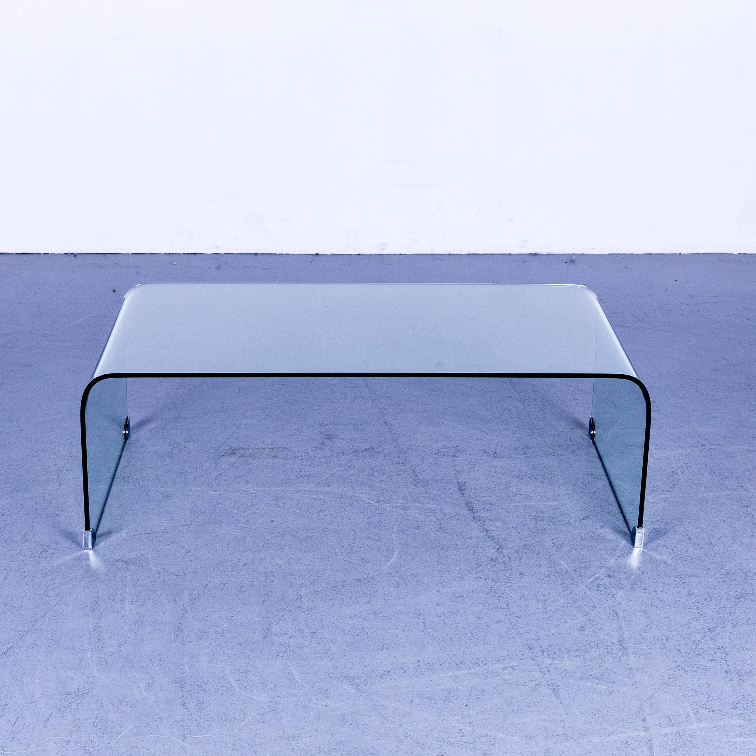 Designer coffee table glass with metal feet rounded corners.