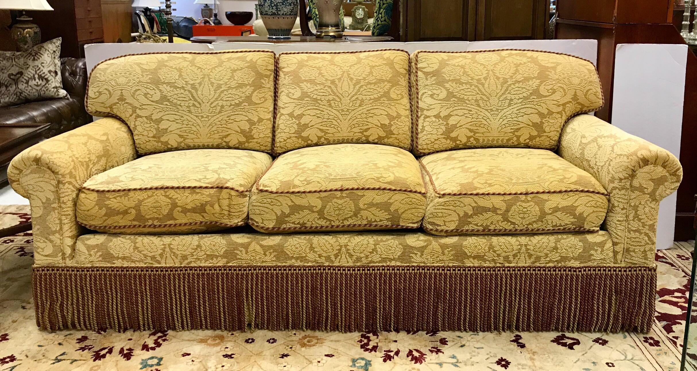 Custom made designer sofa, circa early 21st century upholstered in luxurious damask Brunschwig and Fils fabric and finished with coordinating buillion fringe. Features eight way hand tied construction and down-filled cushions. Both comfy and chic.