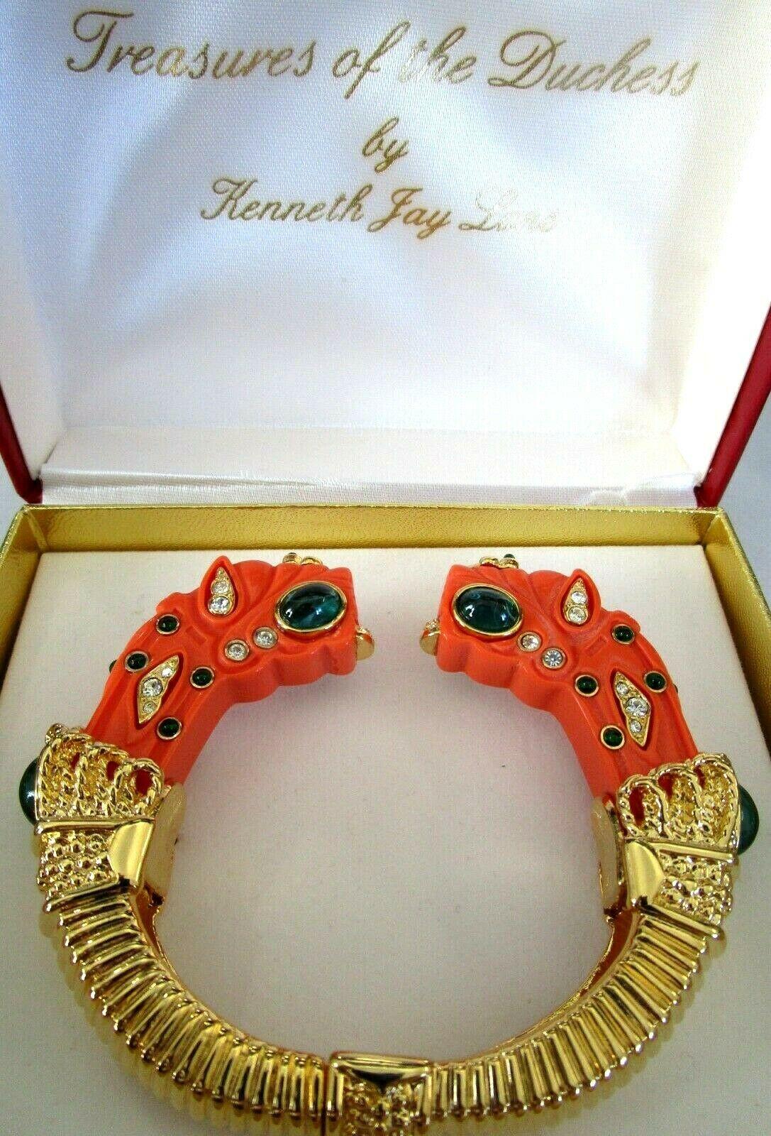 Magnificent Rare simulated Coral Dragon Bracelet. Treasures of the Duchess by Designer Kenneth Jay Lane. Enhanced with simulated Gemstones. Gold tone mounting. Signed hinged Bracelet measures approx. 3 ½” wide x 3” deep x 7/8 high. In unworn