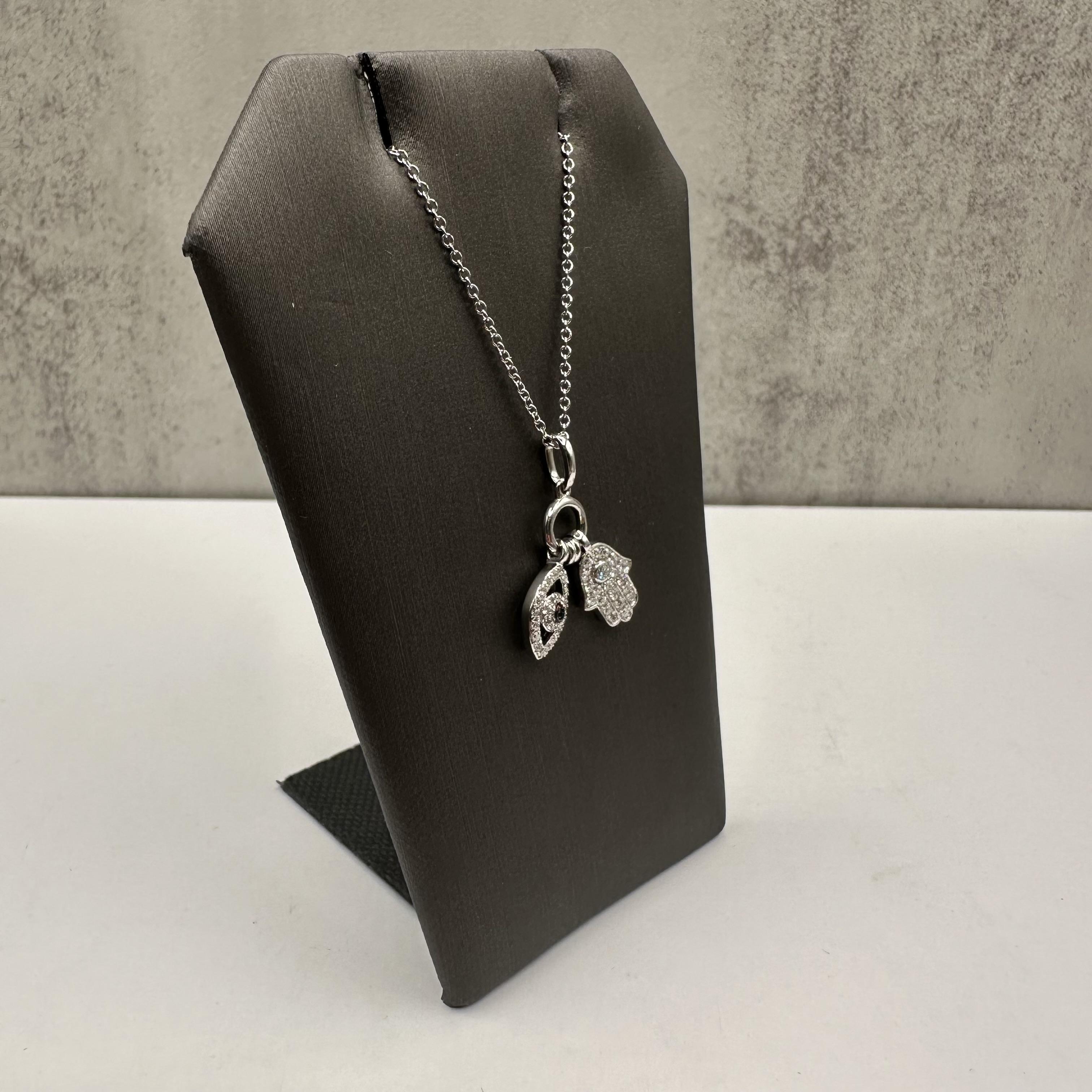 Diese Designer Effy Evil Eye und Hamsa Halskette ist sowohl elegant als auch bedeutungsvoll, gefertigt in luxuriösem 14kt Weißgold. Mit einem Gesamtgewicht von 0,24 Karat (ctw) natürlicher Diamanten der Farbe GH und der Reinheit SI in einer Mischung