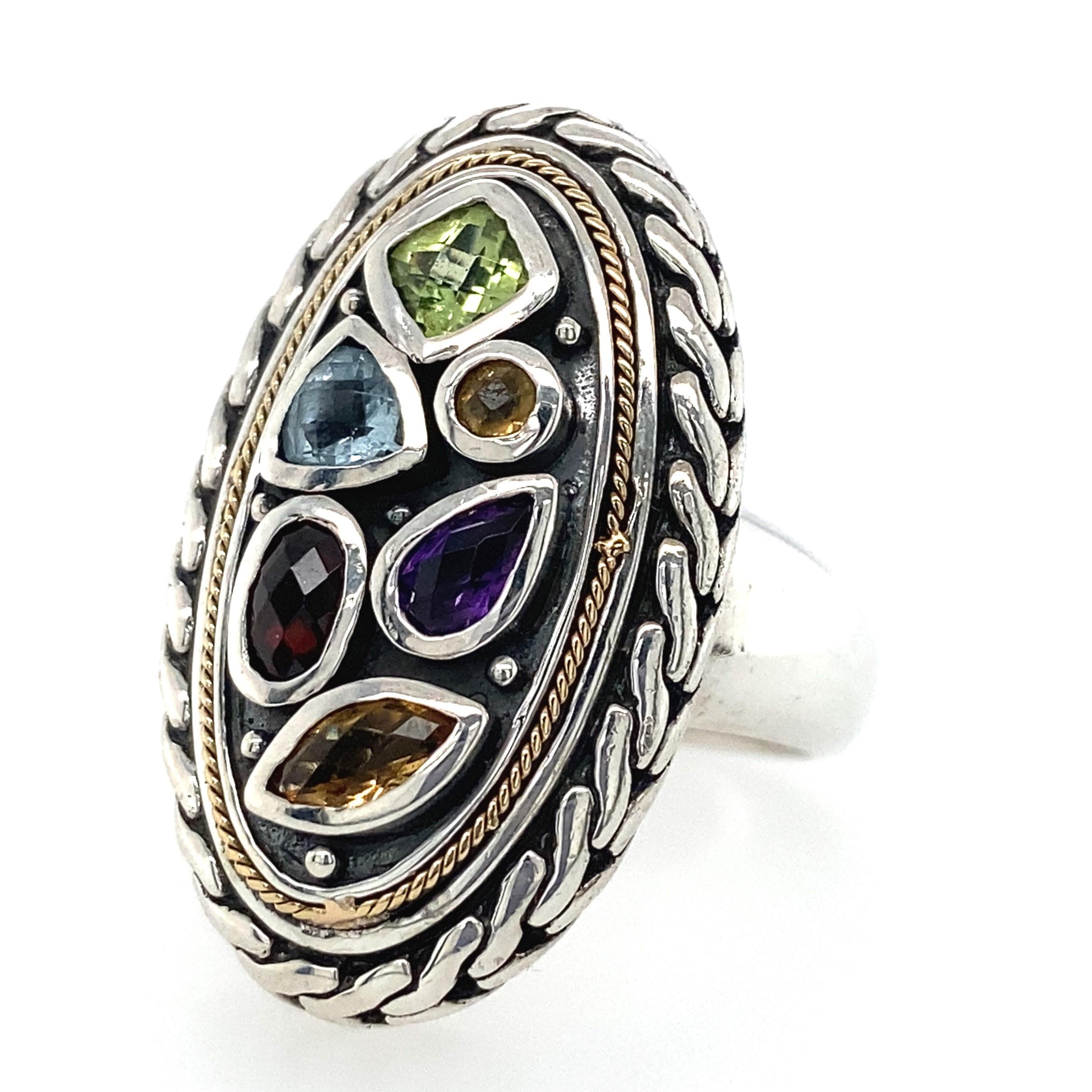 This vintage designer Effy ring has everything Effy is known for: statement piece with lots of color! The center of this ring features a bevy of bezel set gemstones: a 0.22 ct garnet oval, a 0.13ct amethyst pear, a 0.15ct blue topaz trillion, a