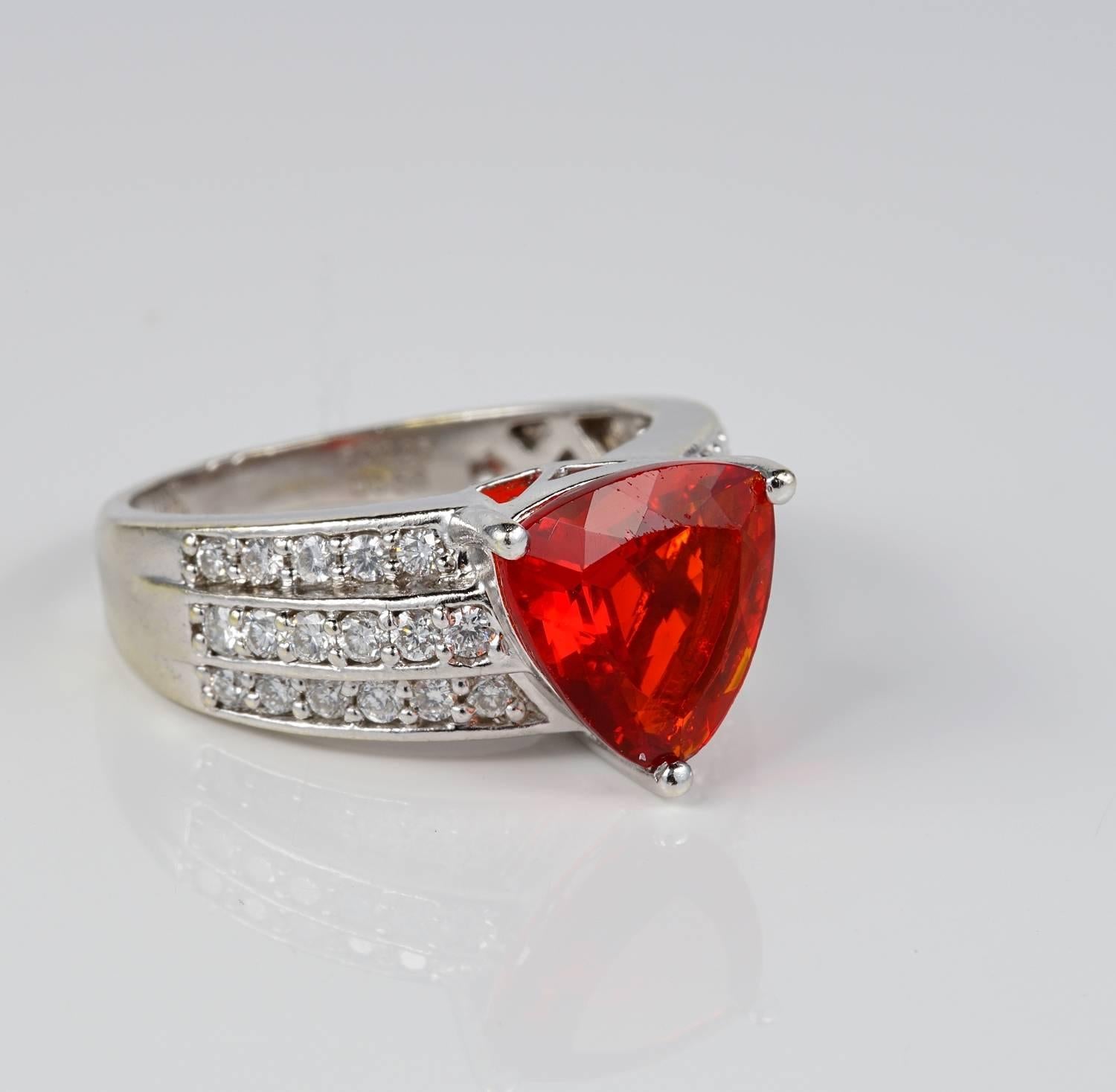 An exceptional focal point is made by the triangular cut Natural Fire Opal set in the middle. Strong, vivacious RED ORANGY colour so lively and unique which is rare to find in Fire Opals, quite a statement.
The ring itself is modelled like a Diamond