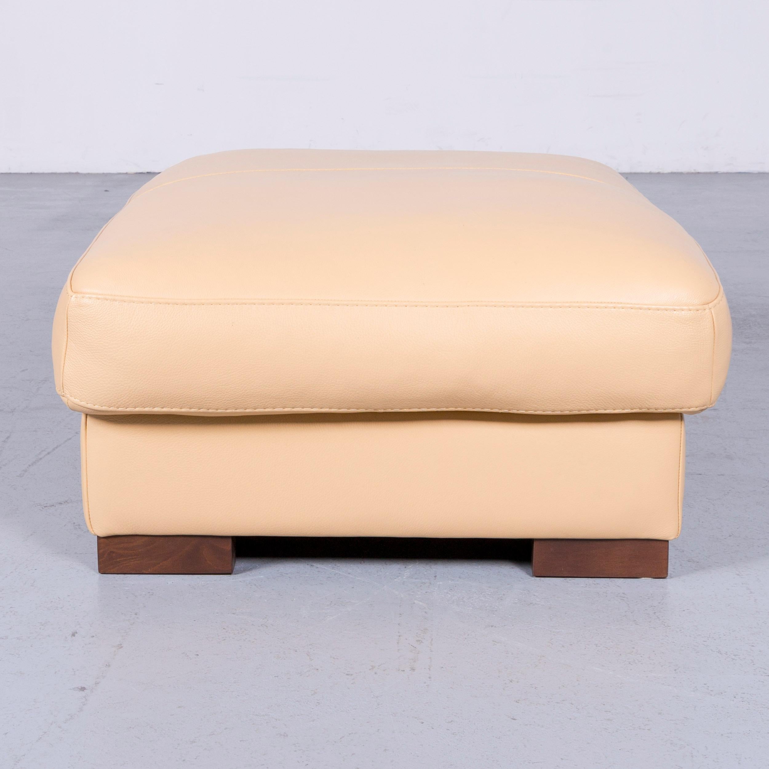 Beige colored designer footstool, in a minimalistic and vintage design, made for pure comfort.
