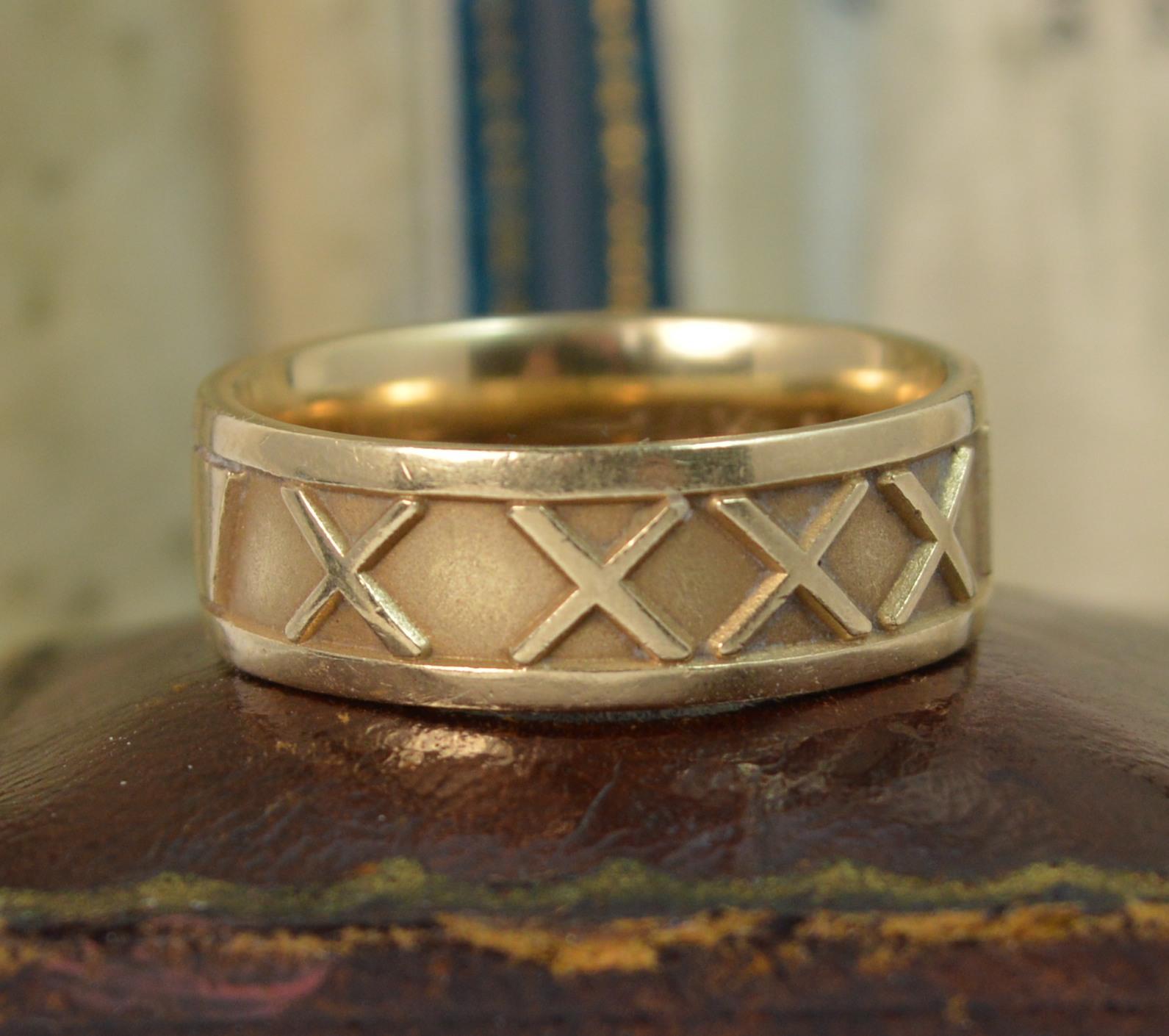 A JOHN CHRISTIAN designed 14 carat gold stack band ring.
SIZE ; P UK, 7 1/2 US
6.8mm wide band throughout.

Designed with Roman numerals throughout; X XXX MCMLXV for 10 / 30 / 1965

CONDITION ; Excellent. Crisp pattern. Clean, solid band. Crisp