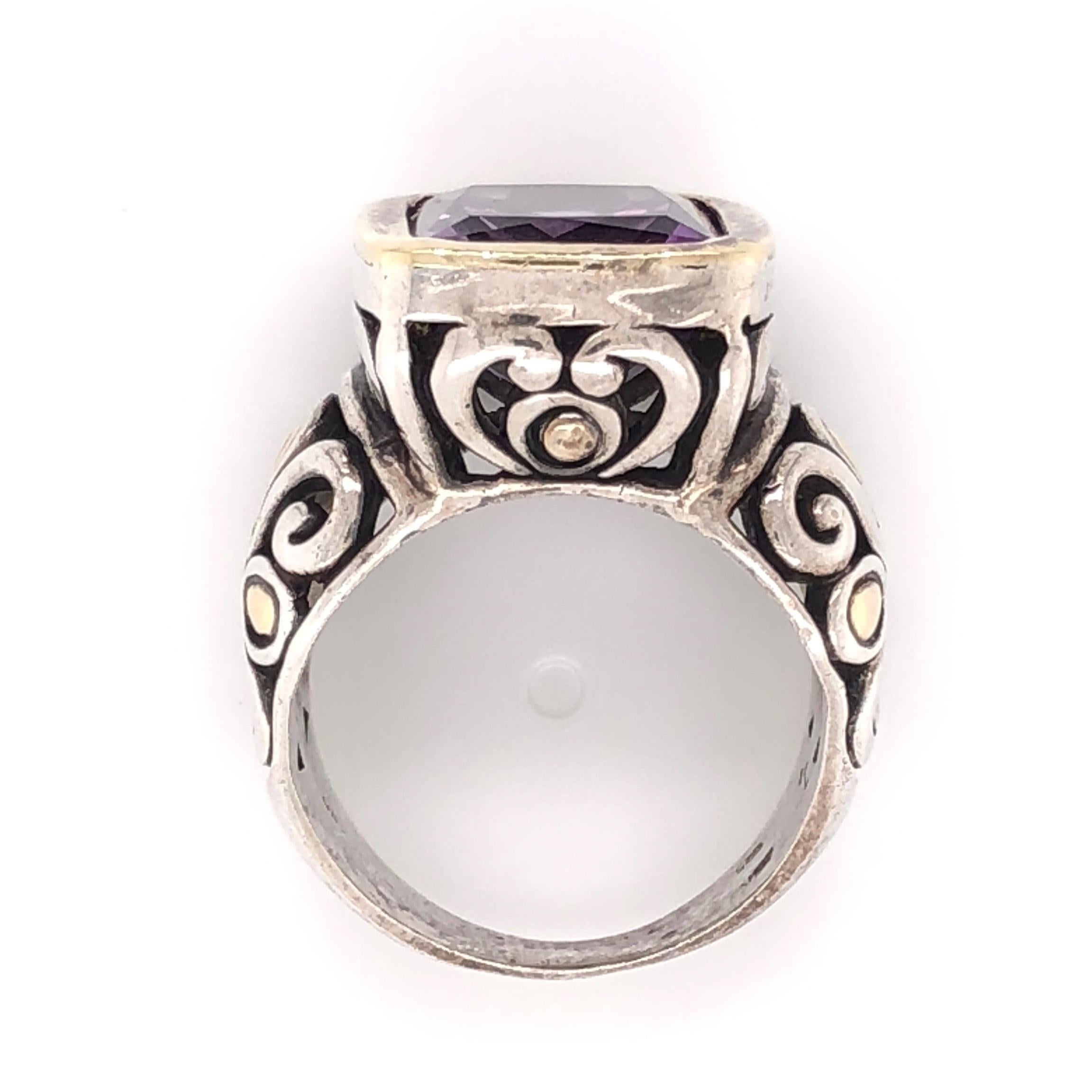 John Hardy 18 Karat Yellow Gold and Sterling Silver Ring, center securely set with an Amethyst. Ring Size 7. Beautifully Hand crafted in 18 Karat Yellow Gold and Sterling Silver. Classic and Timeless...A perfect compliment to every wardrobe! 