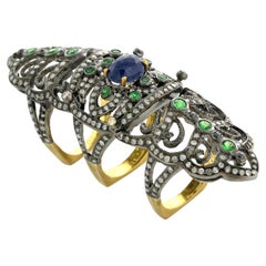 Bague longue de créateur en or 18 carats et argent sertie de diamants, saphirs bleus et émeraudes
