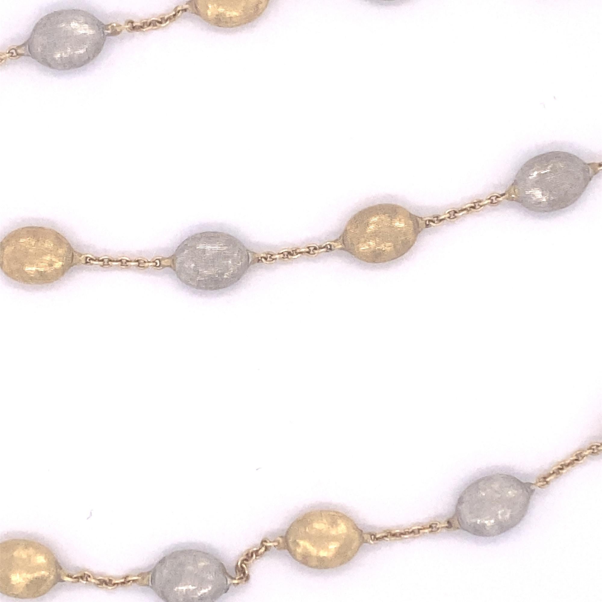 This is a beautiful designer Marco Bicego Siviglia multicolor 18K gold necklace. The necklace has 21 baroque etched gold beads in alternating white and yellow gold. The necklace measures 16 1/8