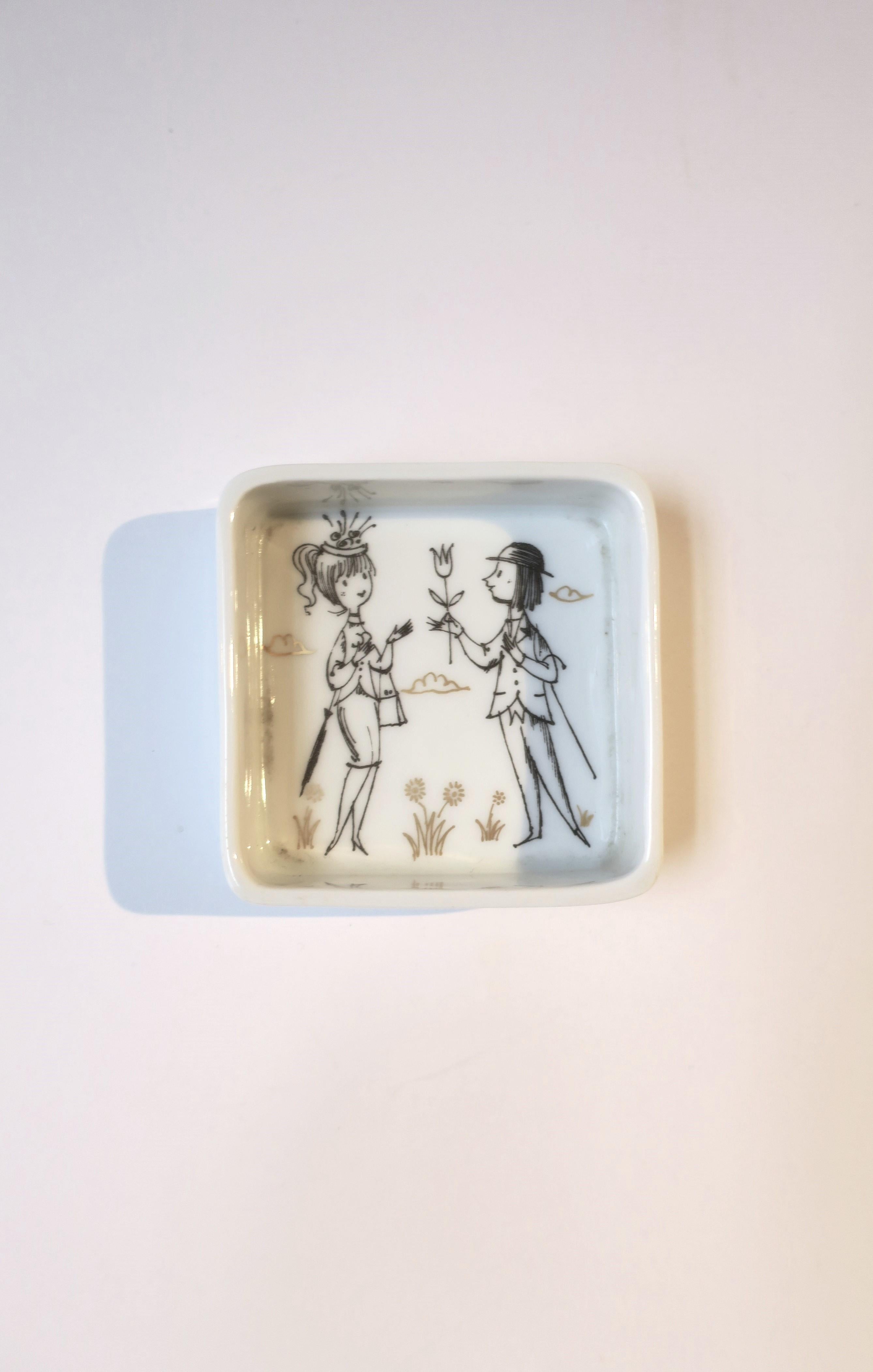 A German white porcelain jewelry dish with whimsical design by designer Raymond Peynet for Rosenthal Studio-Line, Midcentury Modern period, circa mid-20th century, Germany. Dish shows two people, beautifully dressed, perhaps in a park, with the man