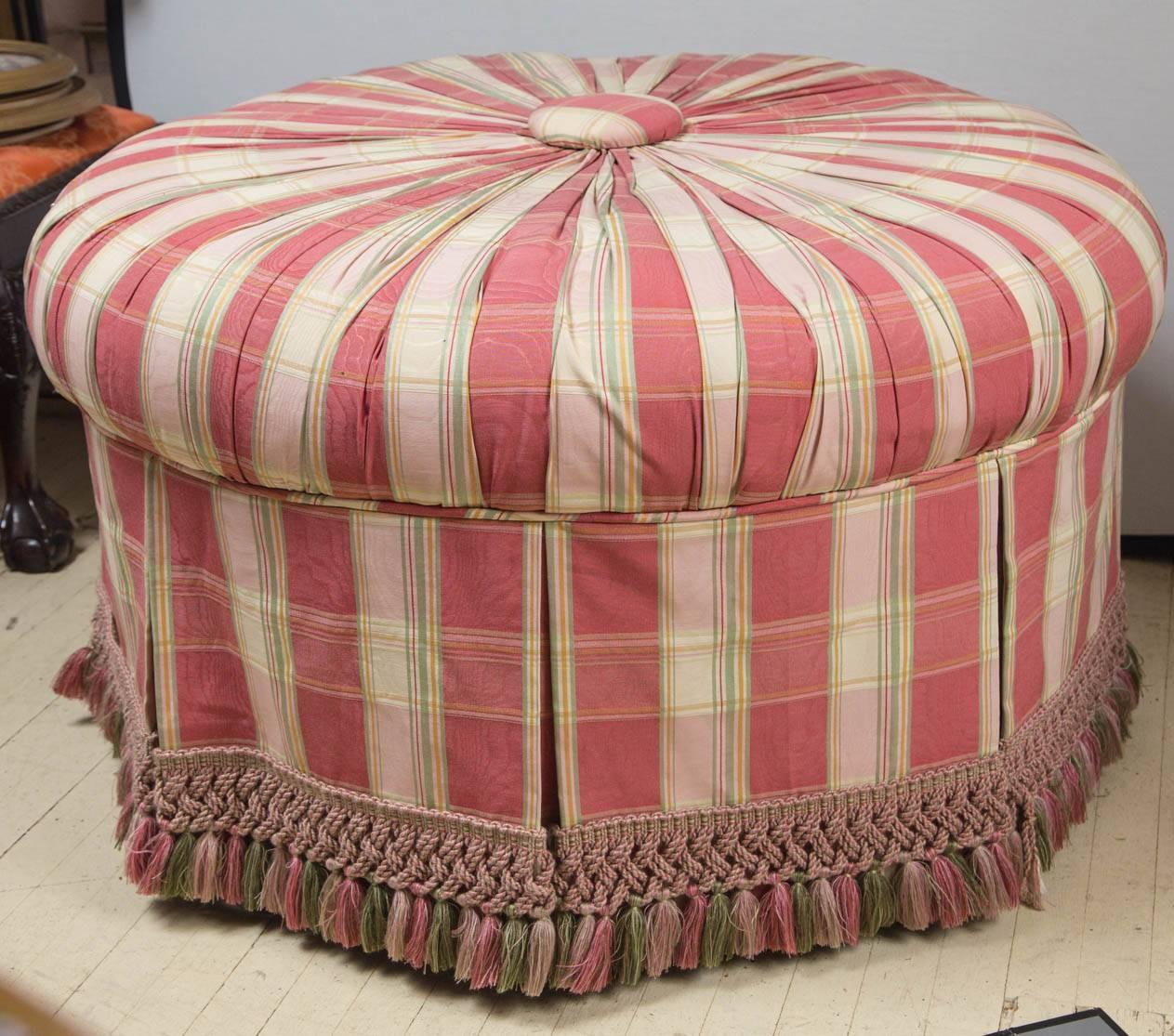 Large round pouf, fully upholstered in pleated fashion, with a central large 