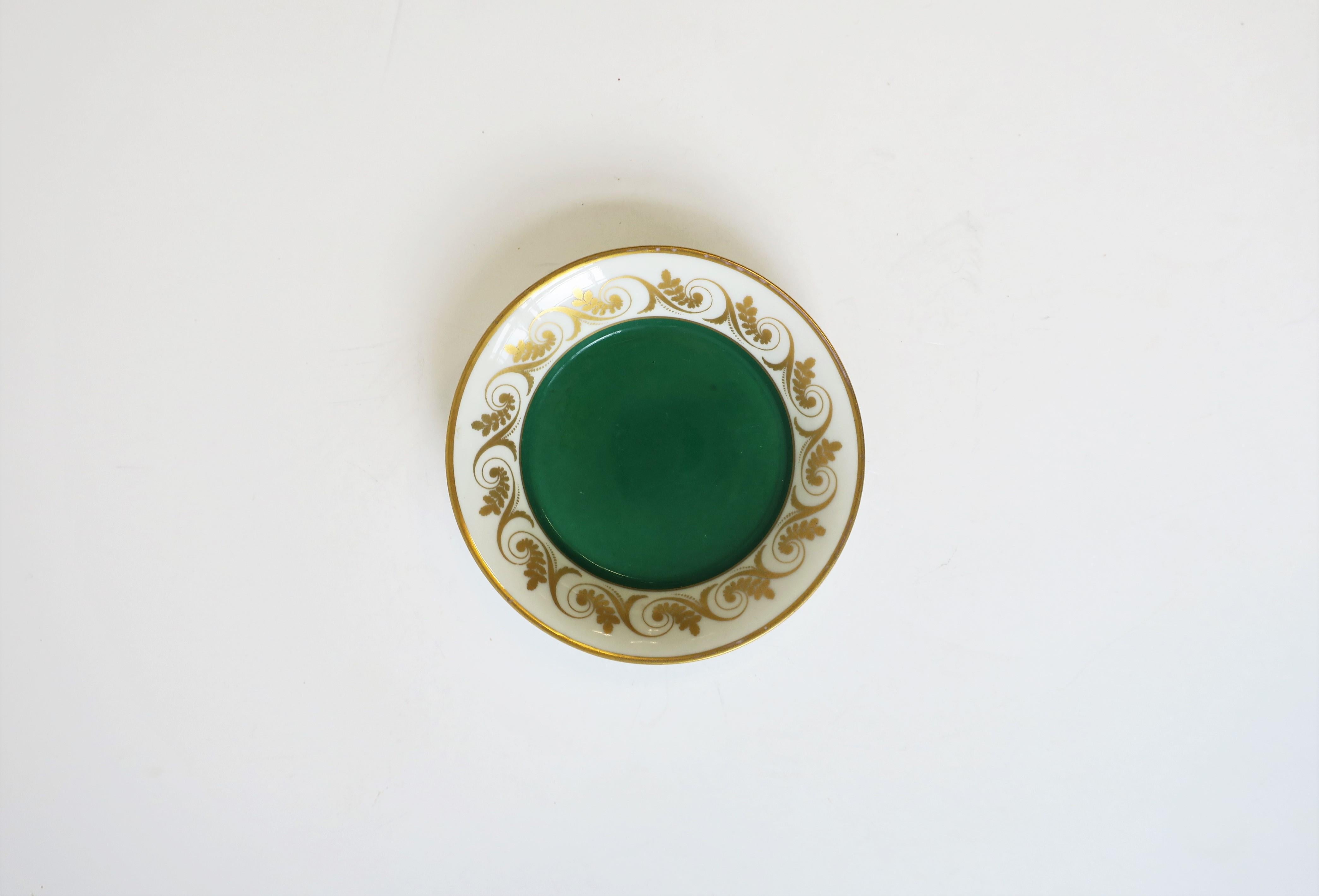 A beautiful Italian porcelain dish by designer Richard Ginori with emerald green center and gold decorative edge detail, circa Mid-20th century or earlier, Italy. Colors include green, gold, and white porcelain. With maker's mark on bottom as shown