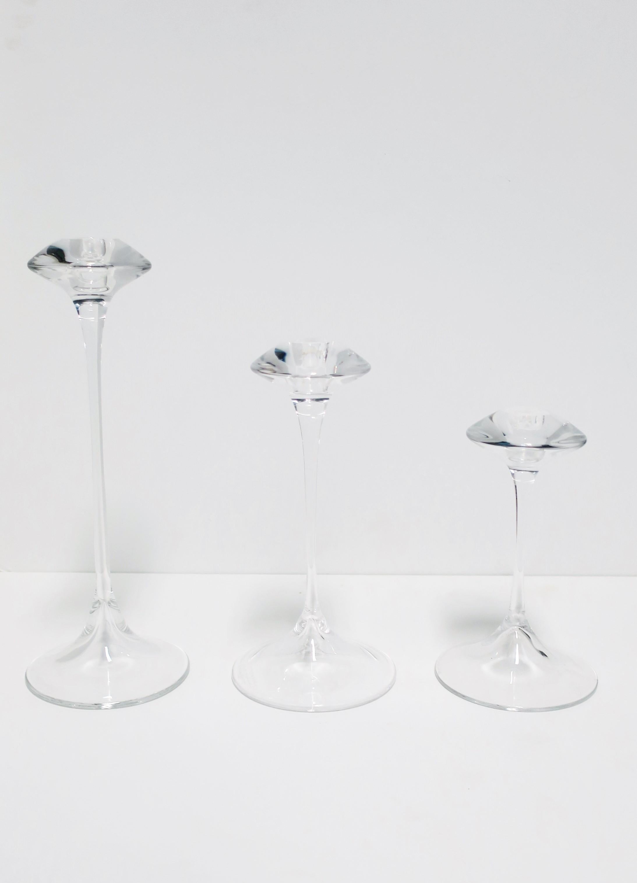 A beautiful set of three (3) of Scandinavian Modern clear crystal candlestick holders by designer Kjell Engman for Kosta Boda, Sweden. With maker's mark, designers' signature, and numbered on underside of all three as shown in images #14, 15 and 16.