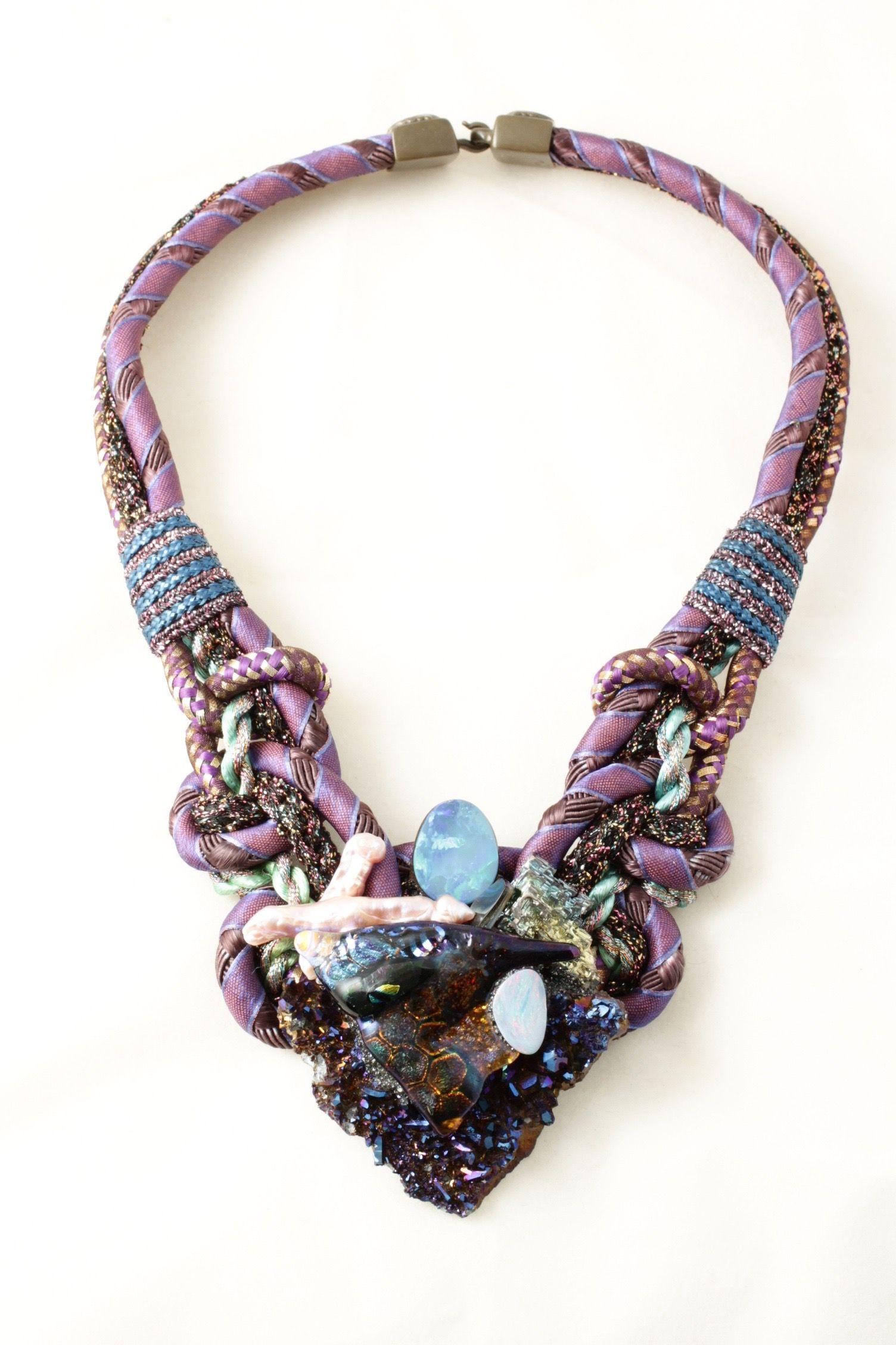 Sencillamente hermoso Firma del diseñador Alex & Lee Collar con forma de babero de piedras preciosas, cristal dicroico, cristal de roca ahumado y bismuto, perlas y cordón de uva.
El collar mide aprox. 16