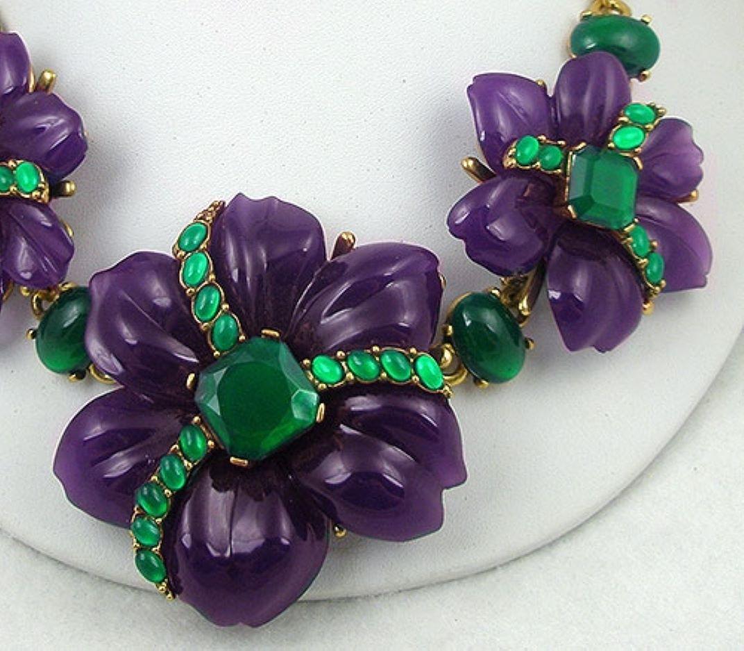 Designer Oscar de La Renta Necklace featuring three large deep Purple and Green resign Flowers with the largest flower in the center. Each has an emerald green square resin stone in its center and three rows small green resin oval cabochon rows