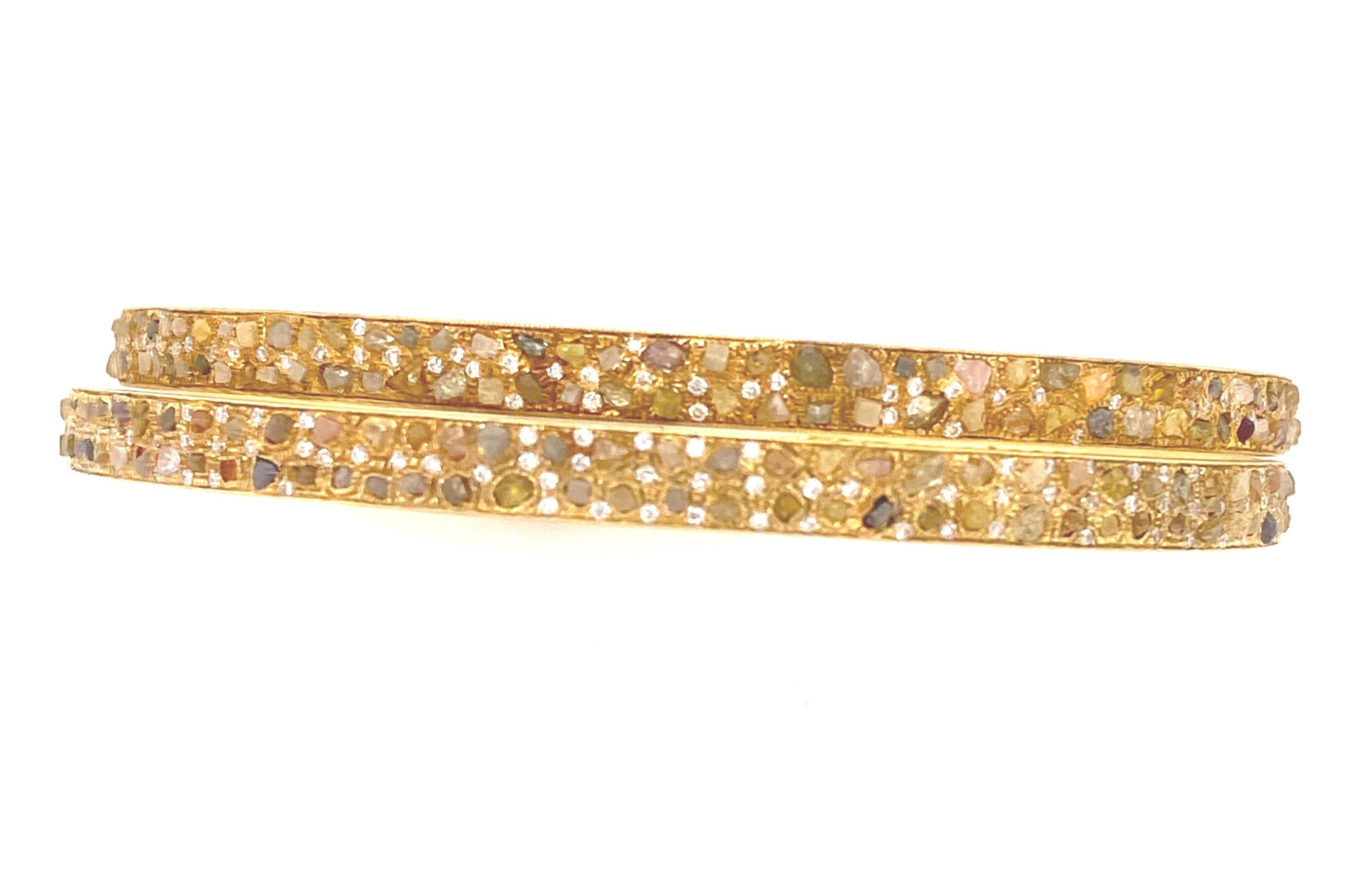 Designer Signed 7.85 Carats Fancy Color Raw Diamonds 18K Gold Bangle. This is a stunning set of two yellow gold bangle with fancy champagne, yellow, green and brown color rough raw diamonds. There are round accent white diamonds all around the