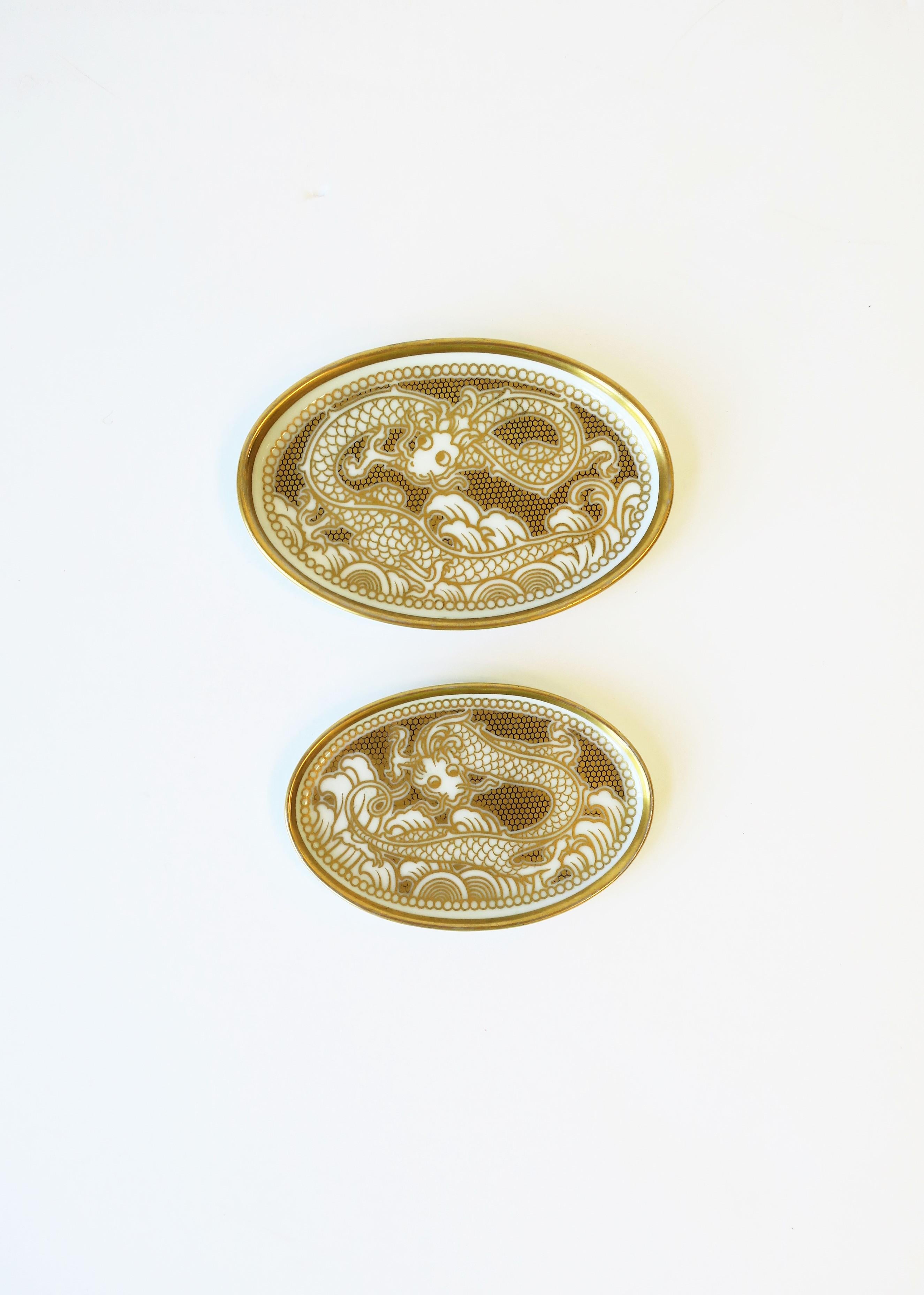 A beautiful, signed set of German white and gold oval porcelain jewelry dishes with dragon design by Rosenthal, circa mid-20th century, Germany. Dishes are signed on back by designer (see images #17 and 18.)  Beautiful pieces to hold jewelry,