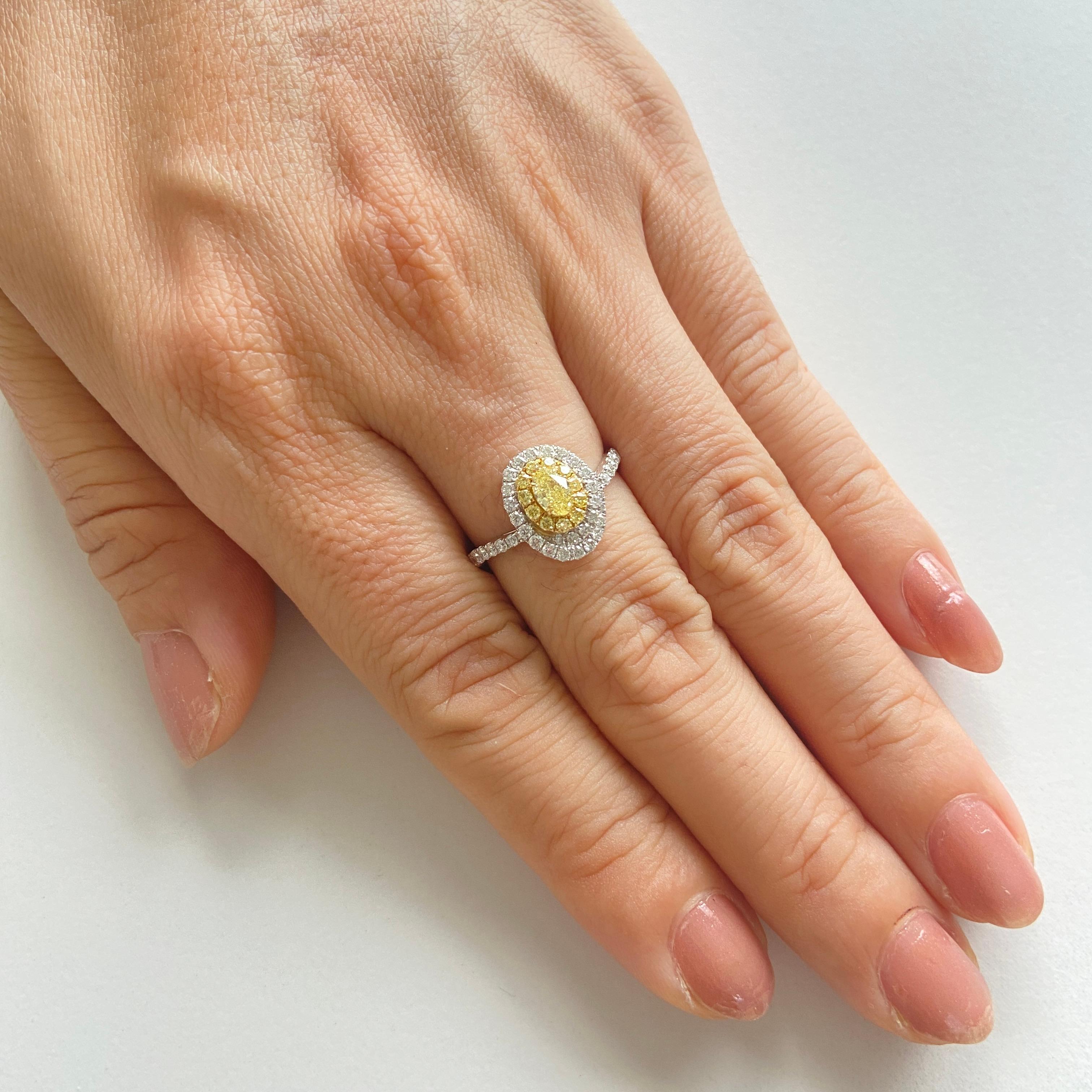 Individuelles Design, das den ovalen gelben Diamanten mit einem Halo aus gelben und weißen Diamanten hervorhebt. Der Ring ist eine perfekte Kreation mit einem einzigartigen Motiv.

-	Der Diamant in der Mitte ist ein CGL Lab Certified Fancy Yellow