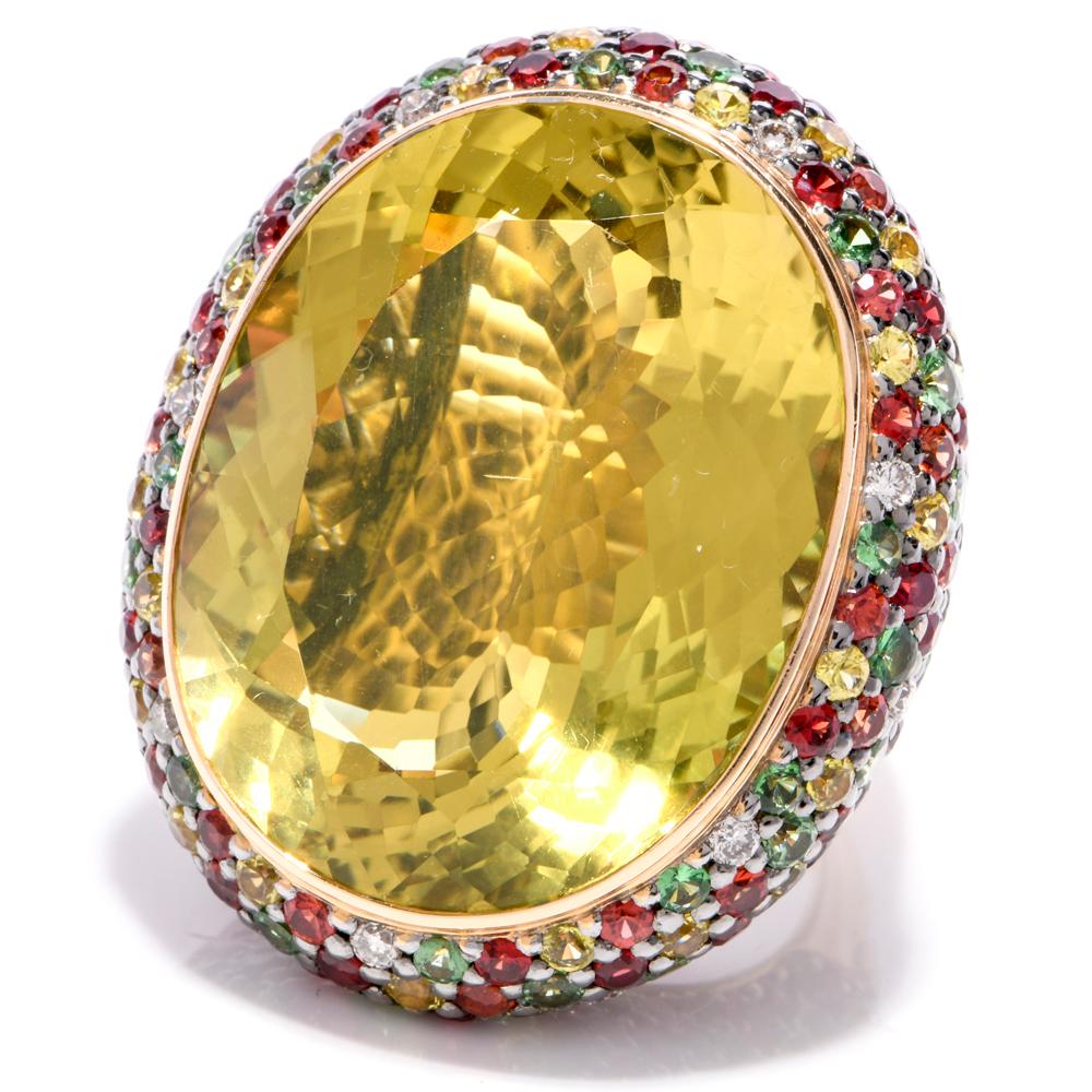 This opulent design cocktail ring is crafted in 18 karat yellow gold, weighing 32.5 grams and measuring 40mm wide. In bold and colorful style, this cocktail ring exposes at the center a large oval-faceted, 65.07 carat lemon topaz. Surmounting a