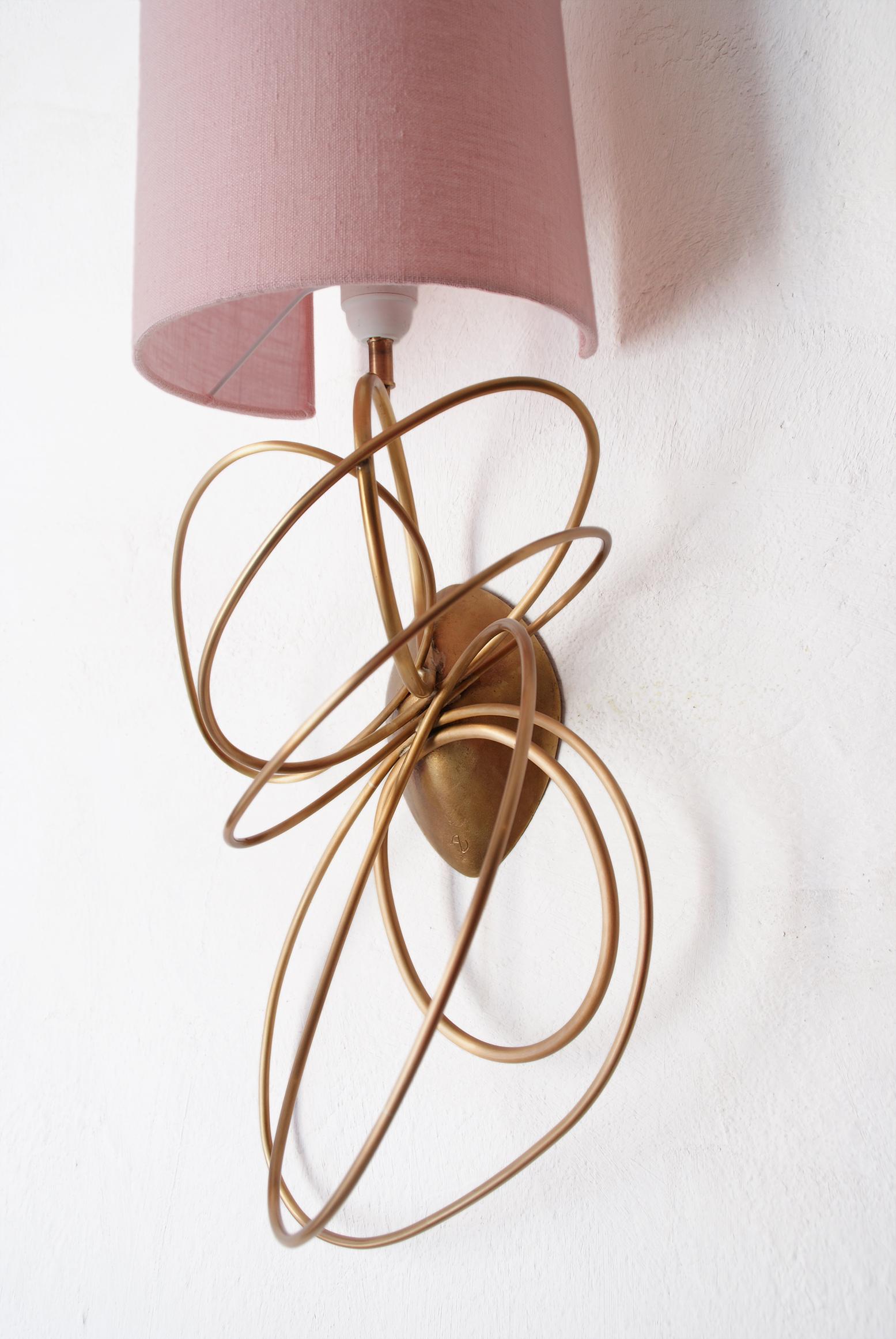 Gorgeous patinated brass sconce, in ellipses forms.
The sconce is in fully patinated brass, included a light pink shade, in linen.
2 Versions available: left and right
This lamp has been made in France, a talented designer artist from the French