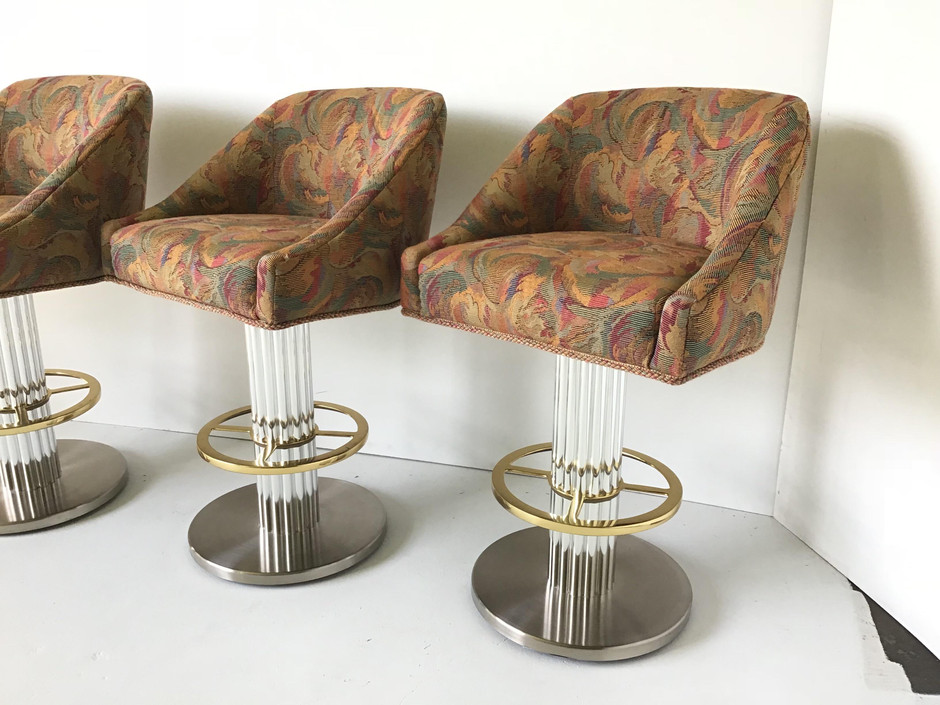 Hello 1980s! This is a set of four Designs for Leisure barstools. They have polished steel bases, chromed fluted pedestals, with brass foot rests. These are the most comfy and stylish barstools ever. They are extremely heavy. This now defunct