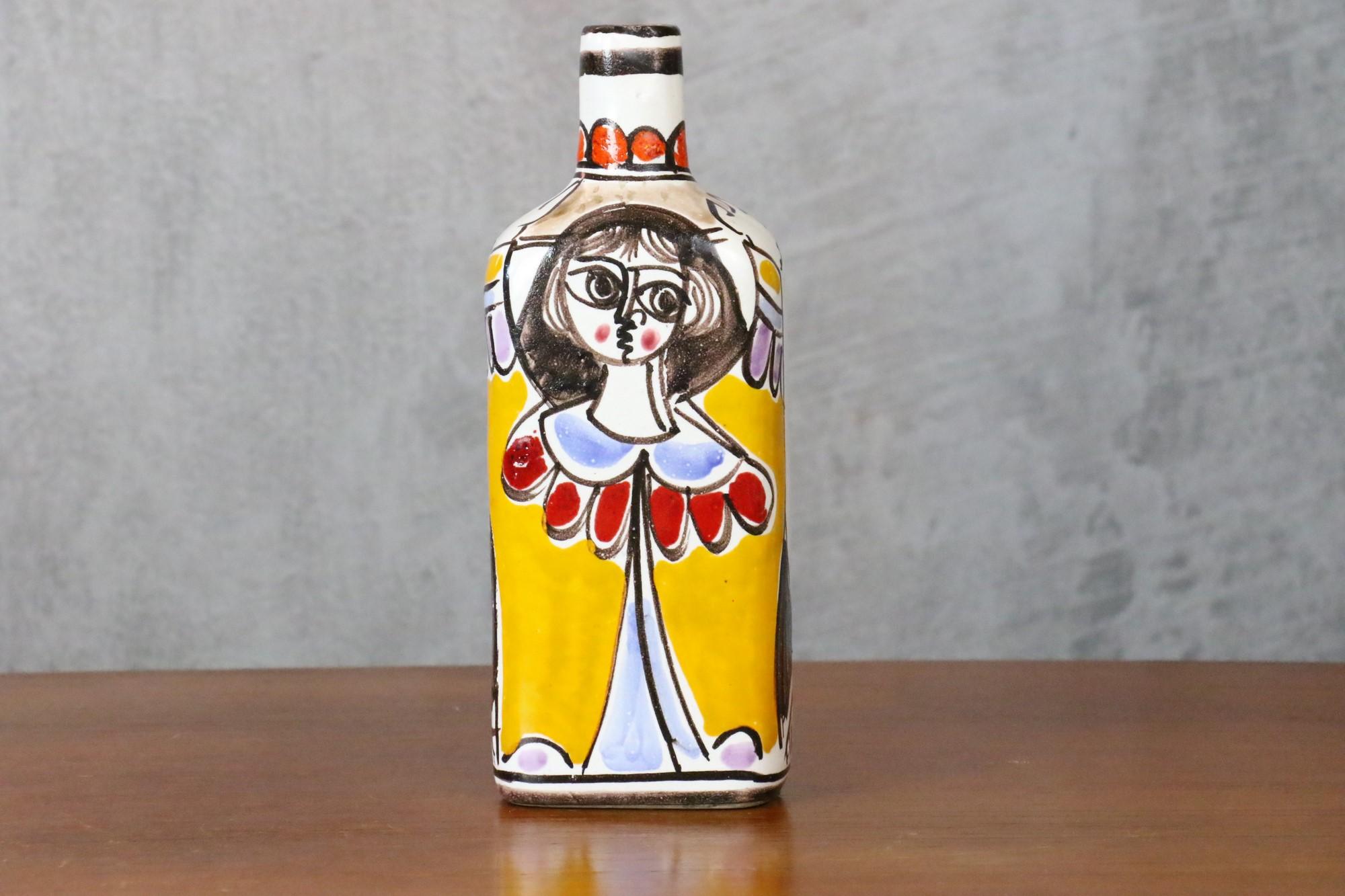 Desimone, hand painted ceramic bottle, Italian Pottery, circa 1960 - Aldo Londi

Very beautiful bottle representing a woman carrying a basket of fruits or vegetables on the top of her head.
We recognize the potter's attraction for traditional