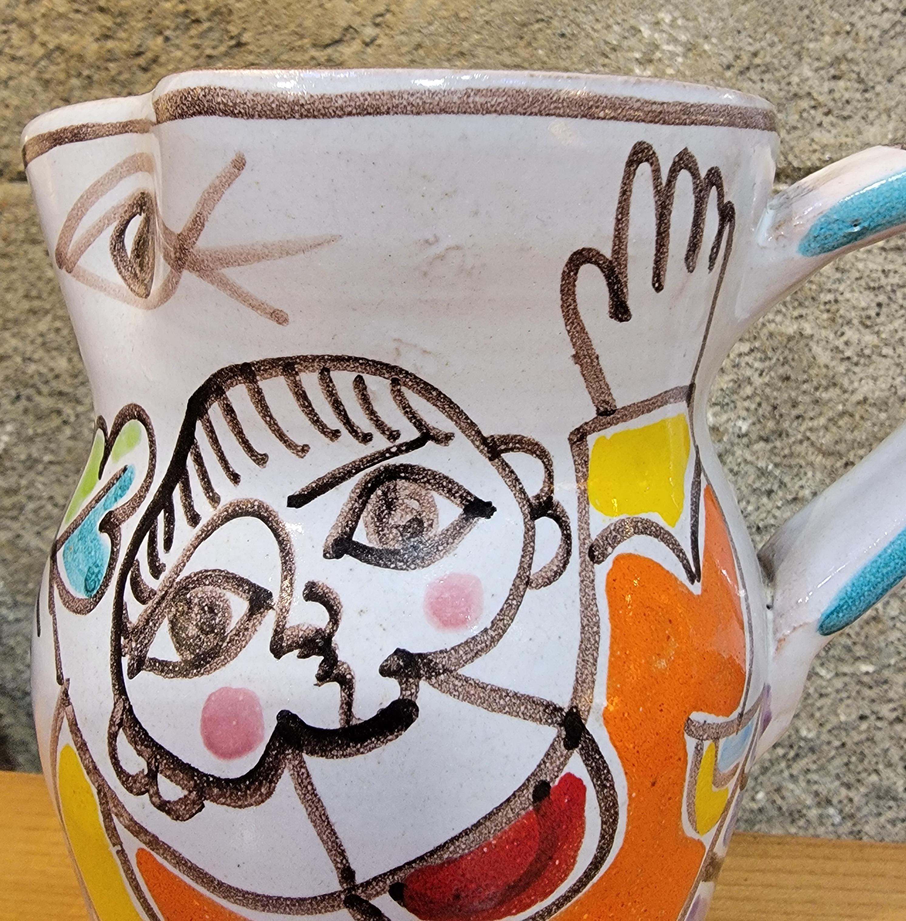 Jarra de cerámica pintada a mano por Giovanni DeSimone. Italia, circa. 1970's. Firmado en la base.

15 cm de alto.
15 cm de ancho.
10 cm de profundidad.
