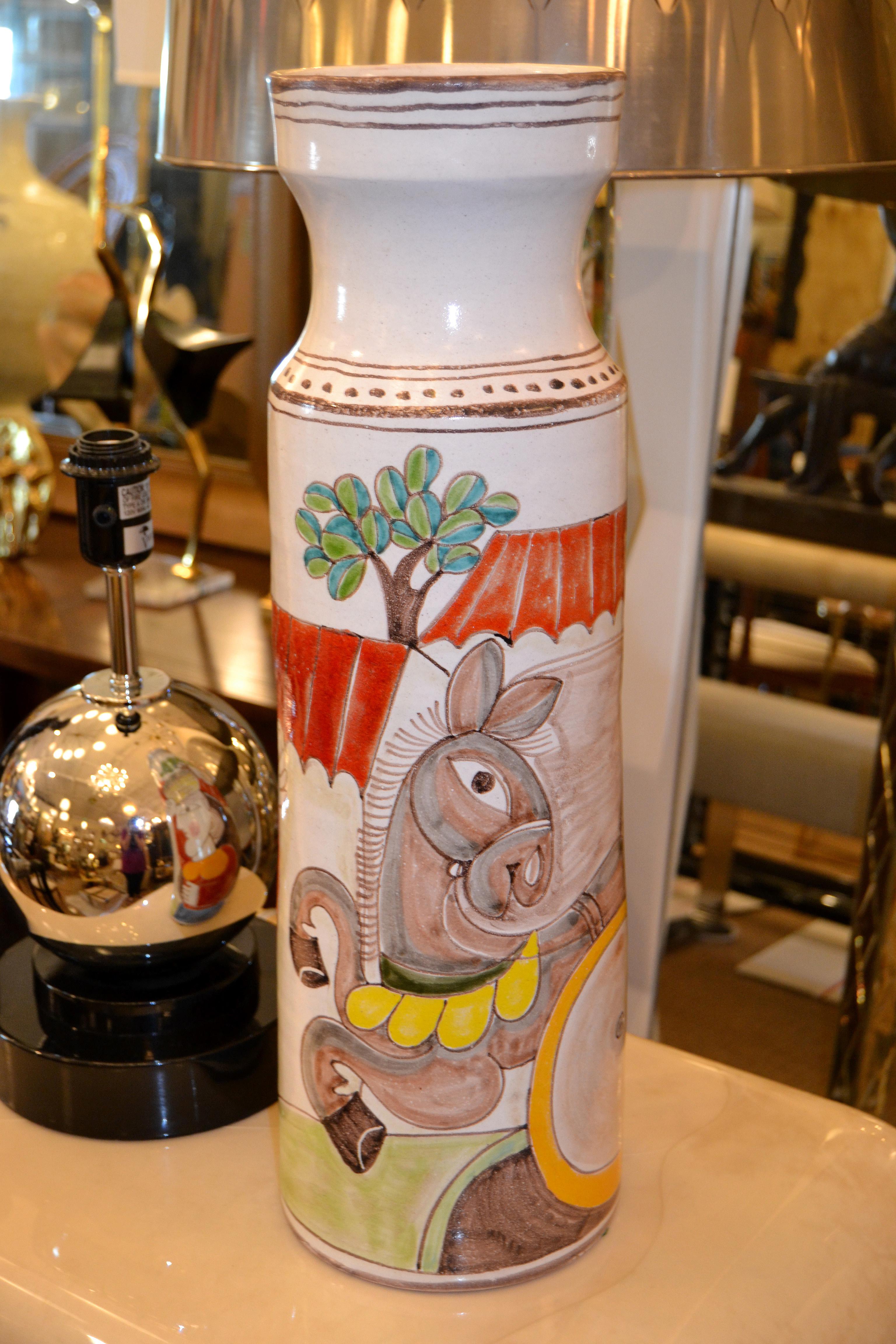 Original Italian Giovanni Desimone hand painted tall art pottery flower vase, vessel.
The glazed vase painting depicts a man and a woman in action picking olives with a donkey.
Marked and numbered on underside, 'Desimone, Italy 13'.
THIS ITEM WILL