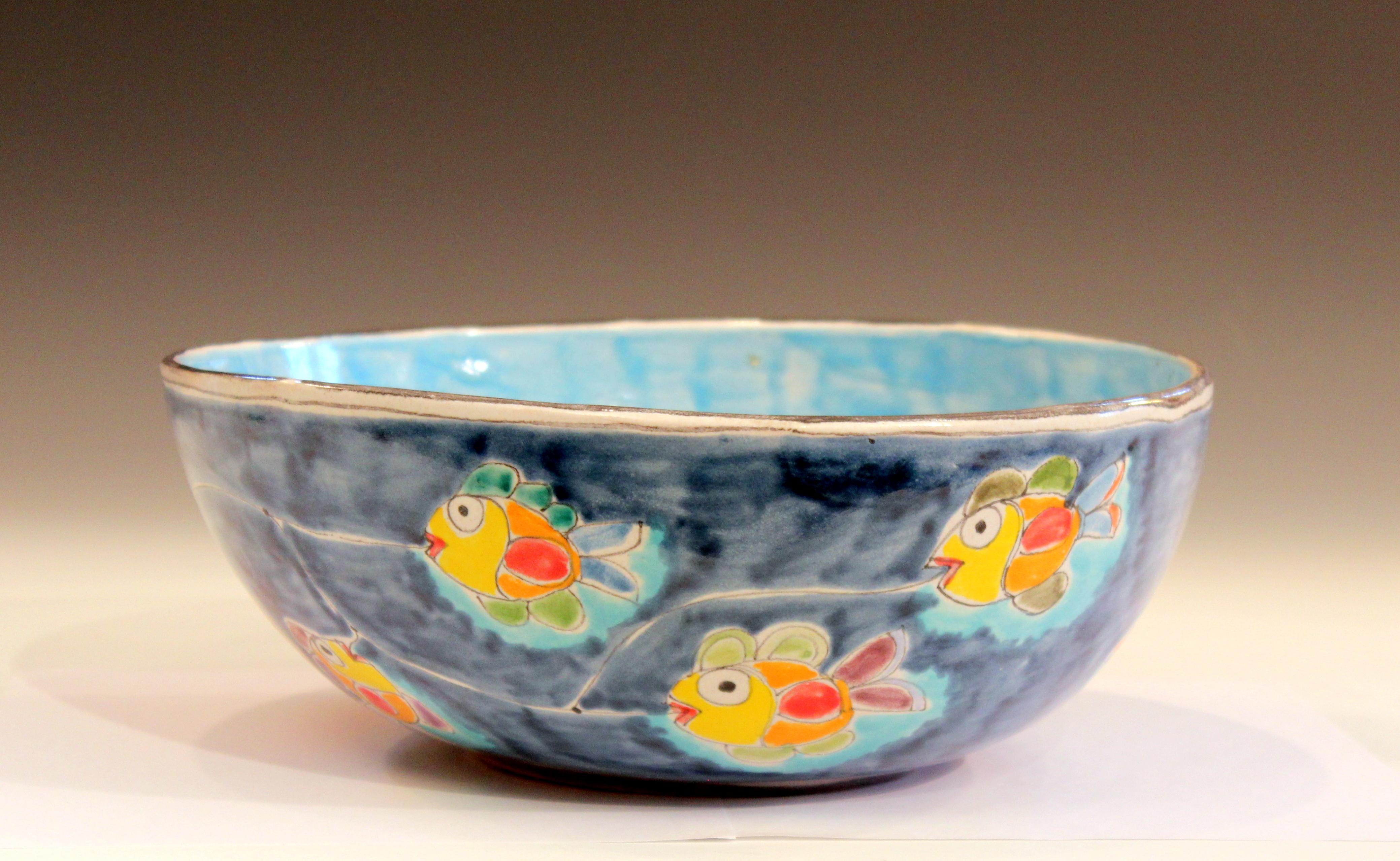 Large vintage handmade DeSimone bowl with festive scene of fisherman in a boat with fish on the line and a squad of squids trailing behind, circa 1960s. Measures: 12