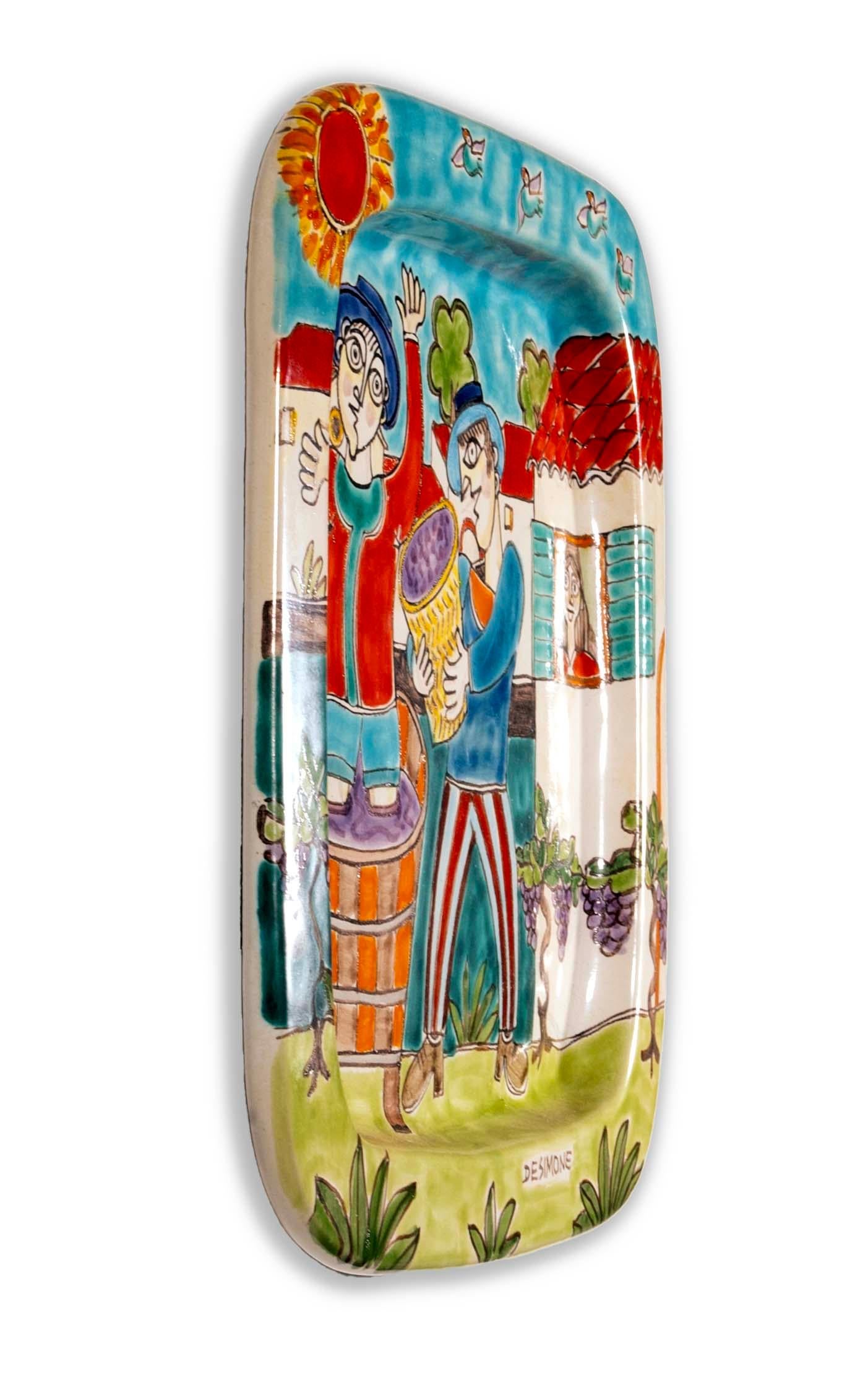 Colorful and charming, this Desimone Vineyard Wine Makers Platter captures the joy of Italian winemaking with its vibrant, hand-painted scene. Signed and numbered #415, this piece is a testament to Desimone's lively and expressive artistic style.