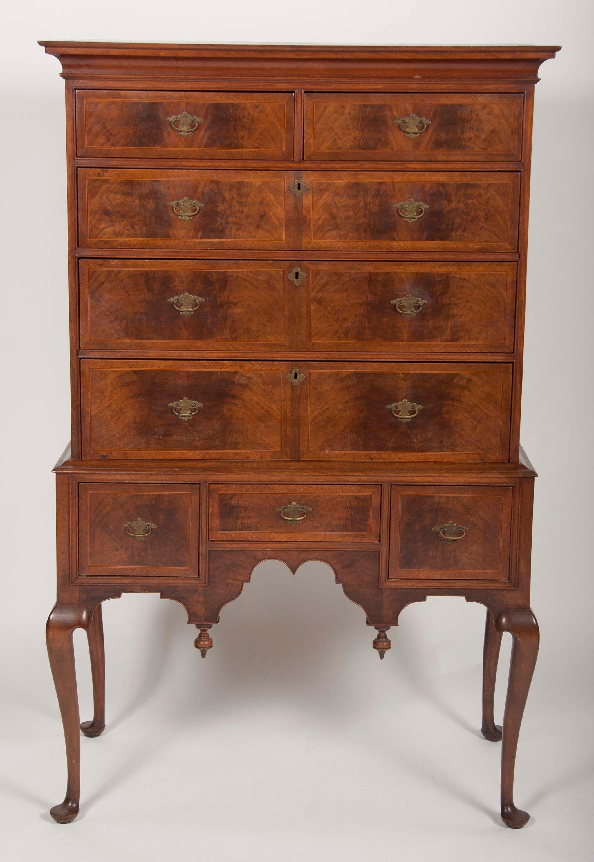 A desirable, diminutive New England two part flat top highboy, in rare transitional William & Mary to Queen Anne form. Top and bottom are original match. Walnut veneer over pine with maple legs. Original hardware. Refinished: small veneer chip above