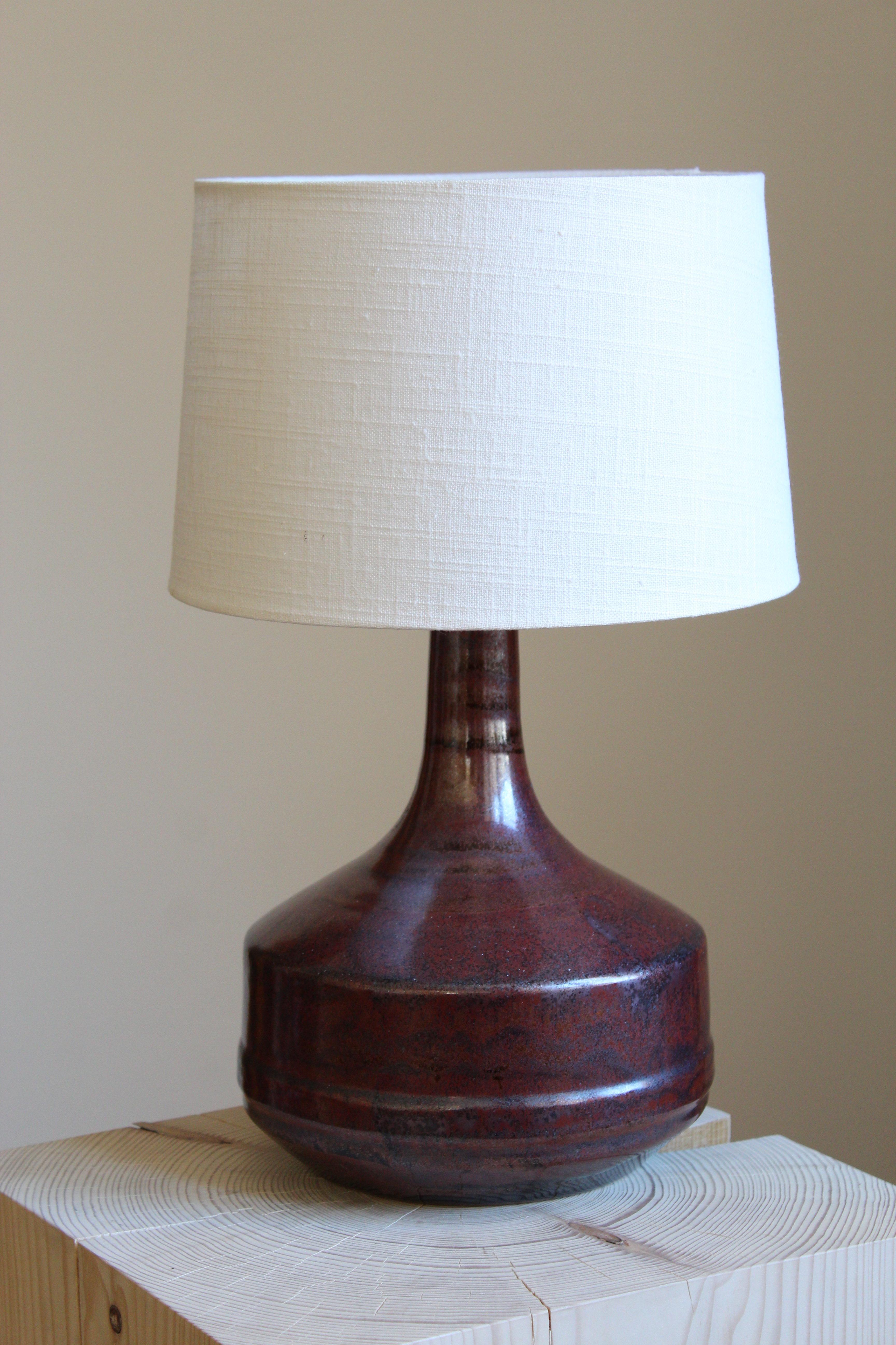 A table lamp, designed and produced by Desiree Stentøj, Denmark, 1960s. stamped. Sold without lampshade.

Glaze features a red-brown color.

Other designers of the period include Arne Bang, Axel Salto, Wilhelm Kåge, and Kähler.