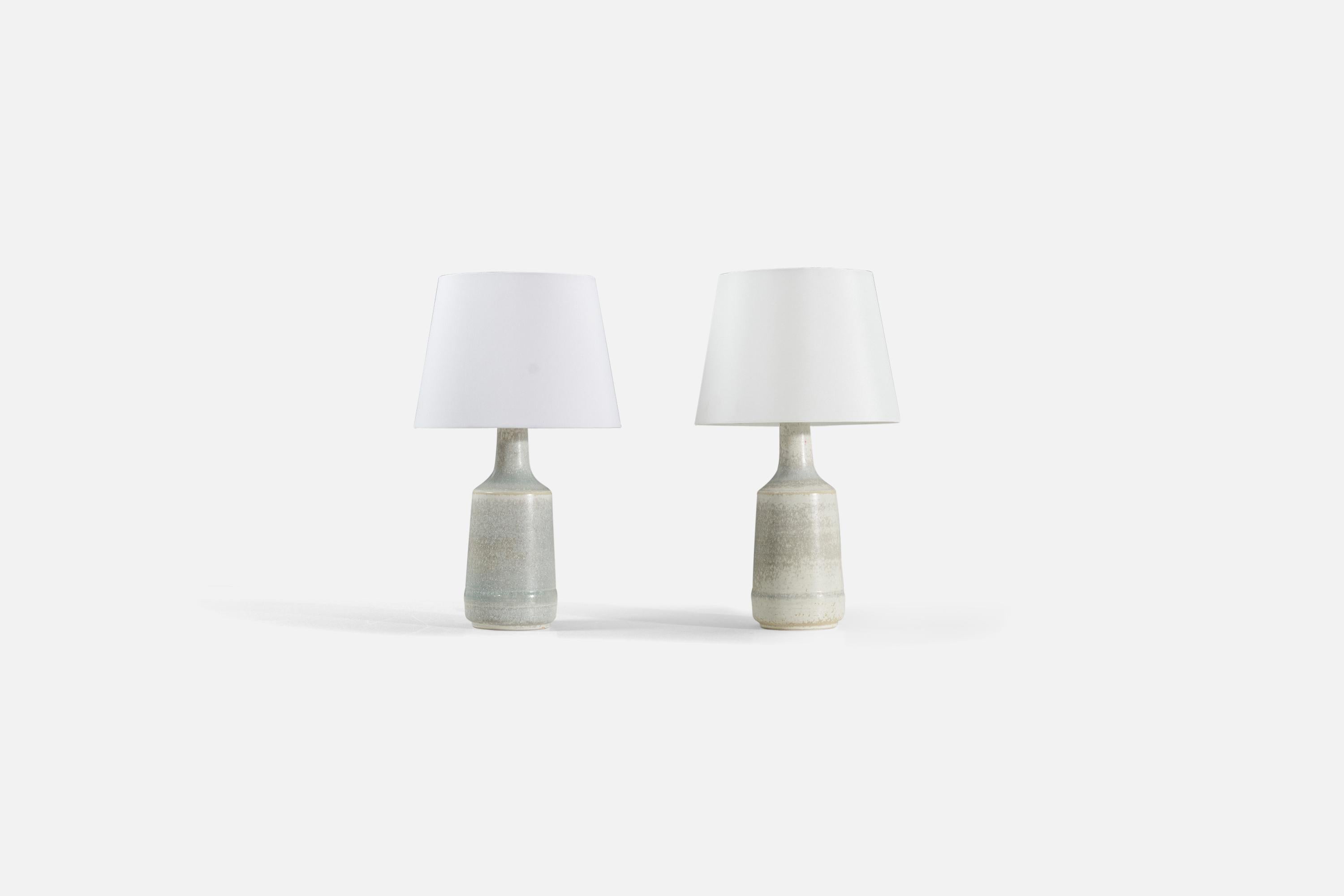 A pair of light gray glazed stoneware table lamps, designed and produced by Desiree Stentøj, Denmark, 1960s. 

Sold without lampshade. Stated dimensions exclude lampshade. Height includes socket. 

Illustrated Shade measures: 9 x 12 x 9
Lamp