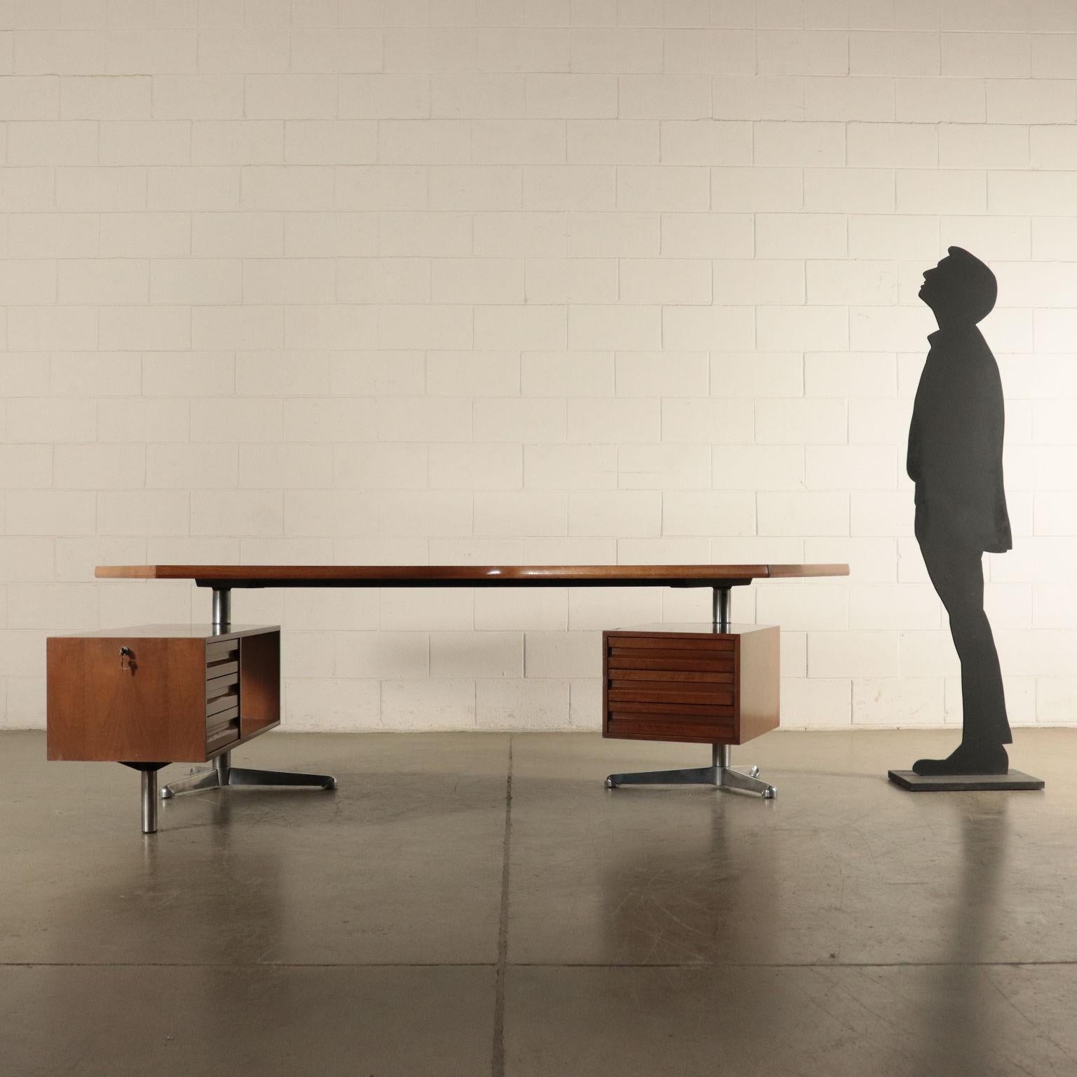 Desk with turning chest of drawers and dactyl; walnut veneered wood and aluminum casting supporting structure. T96 desk was pojected in 1956 in occasion of the ENI decoring of San Donato M.se; the unique shape was inspired by the hexagonal map of