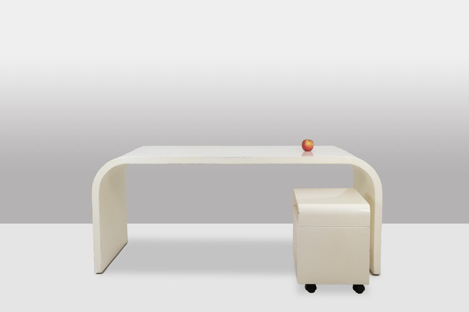Escritorio de esquinas redondeadas con su caja de madera contrachapada lacada en blanco, la caja con ruedas se abre con cuatro cajones.

Obra francesa realizada en la década de 1970.

Dimensiones: Al 75 x An 170 x Pr 80 cm

Referencia: LS56601111A