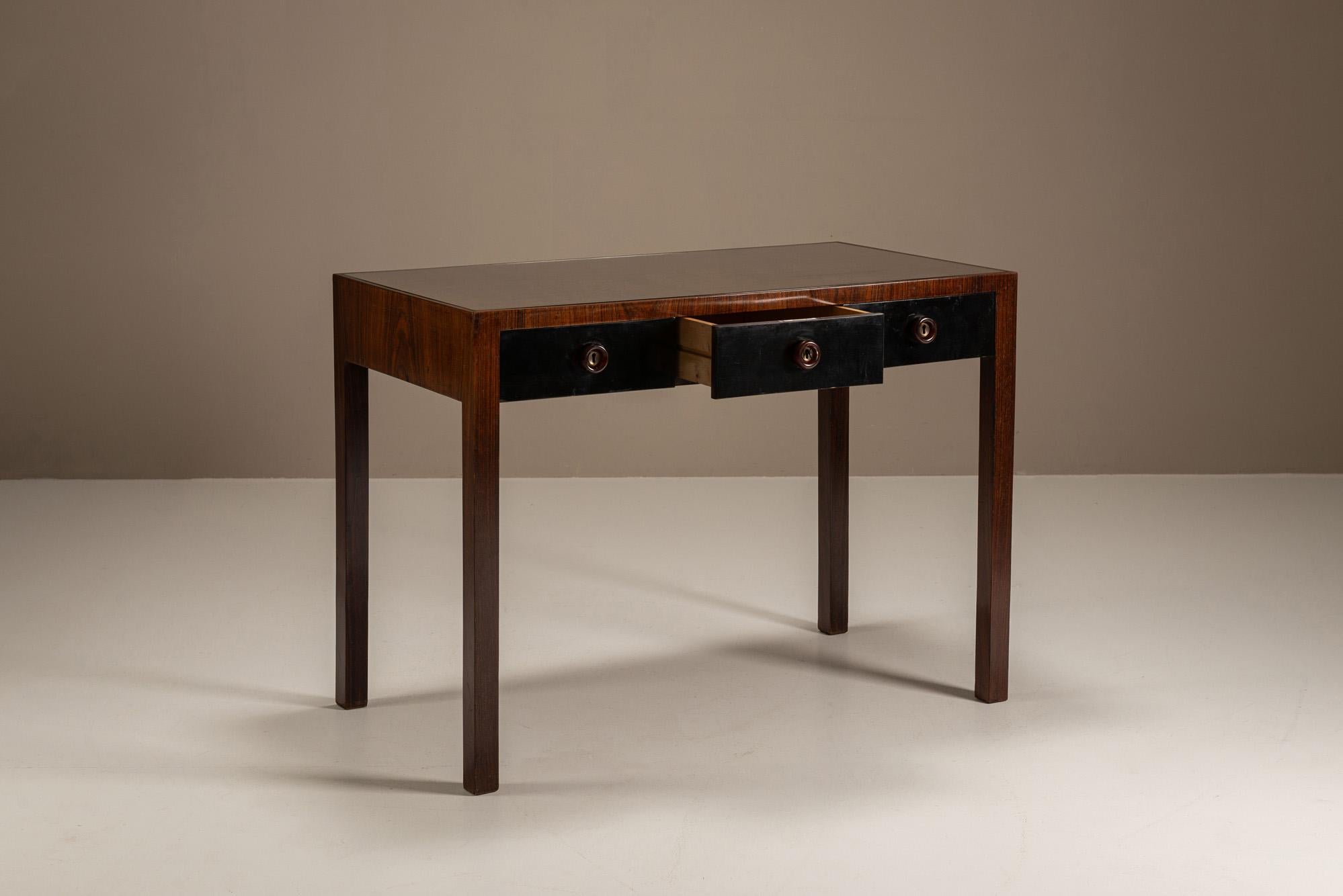Sûre d'elle et posée, cette vanité - ou bureau - attribuée à Vittorio Dassi a été produite en Italie en 1939, à un moment où la sobriété moderniste commençait à remplacer l'excès décoratif.

Design
Construit en bois de rose, le bureau présente une