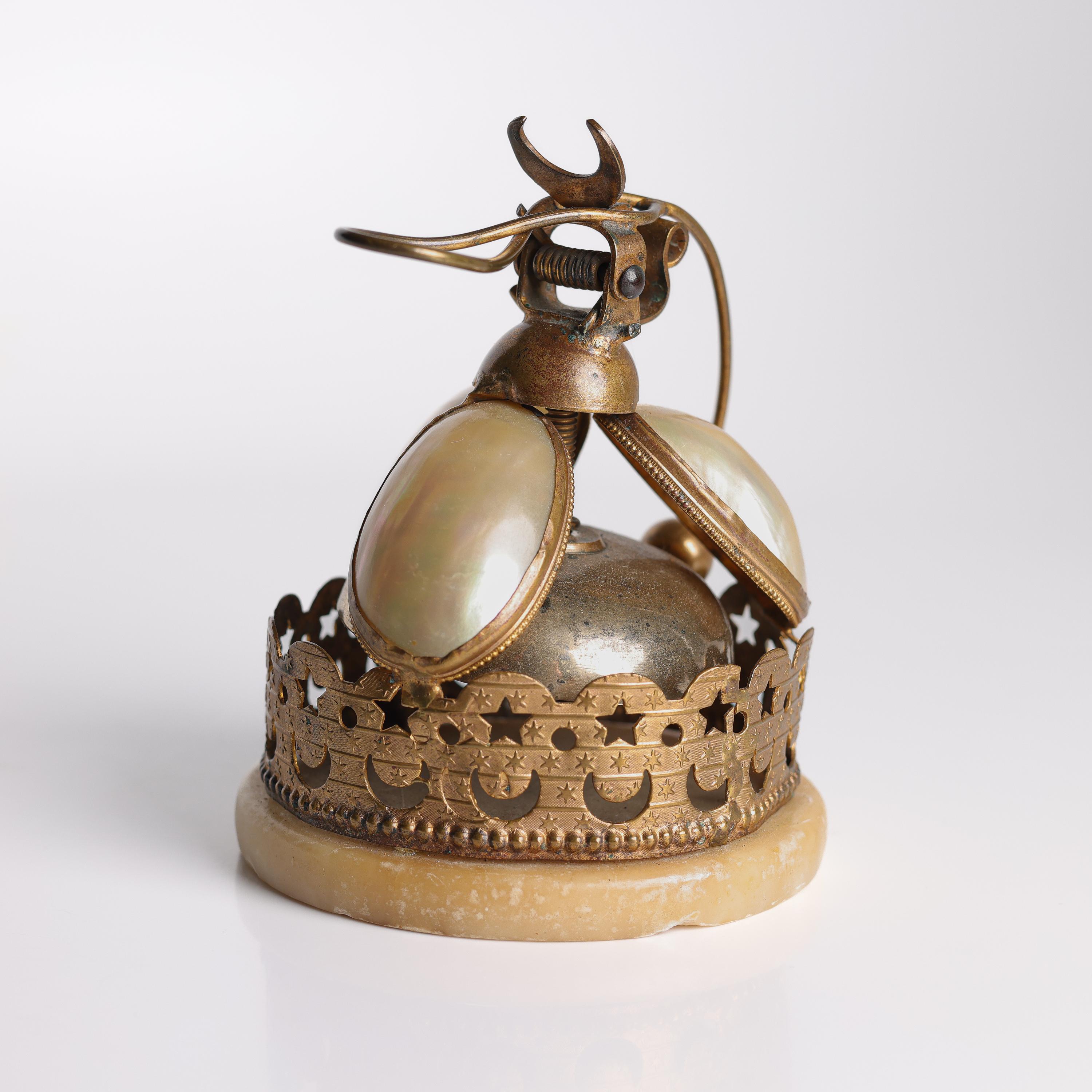 This desk bell is French, and was created near 1870. It's constructed of ormolu; the unique process by which 24K gold is applied to bronze, creating a distinctive finish that was hugely popular in 18th and 9th century France. The striker hits the