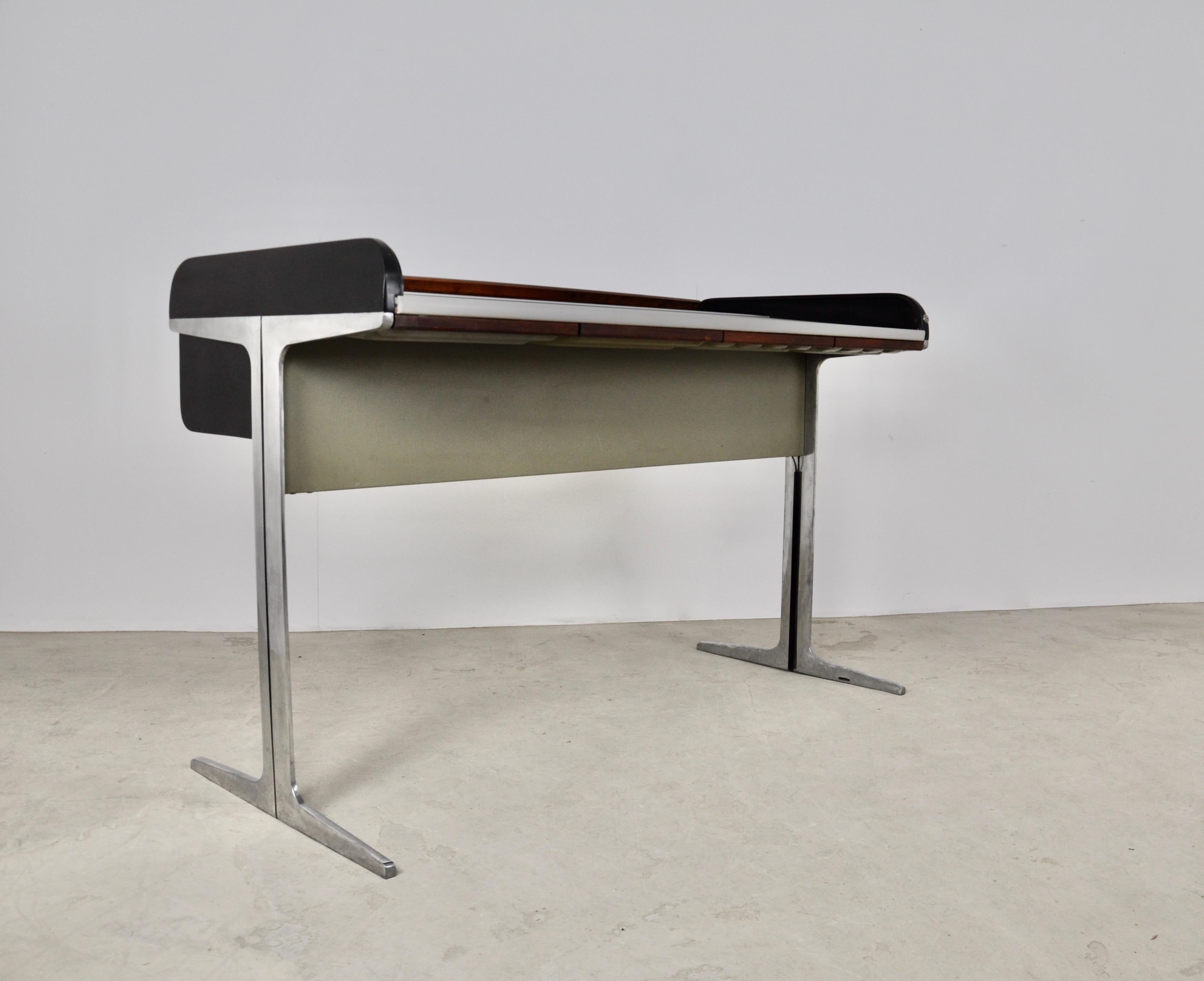 Metal and wood desk, composed of a wooden flap that slides. Wear due to time and age of the desk. Missing crossbar that connects the 2 legs.
 
