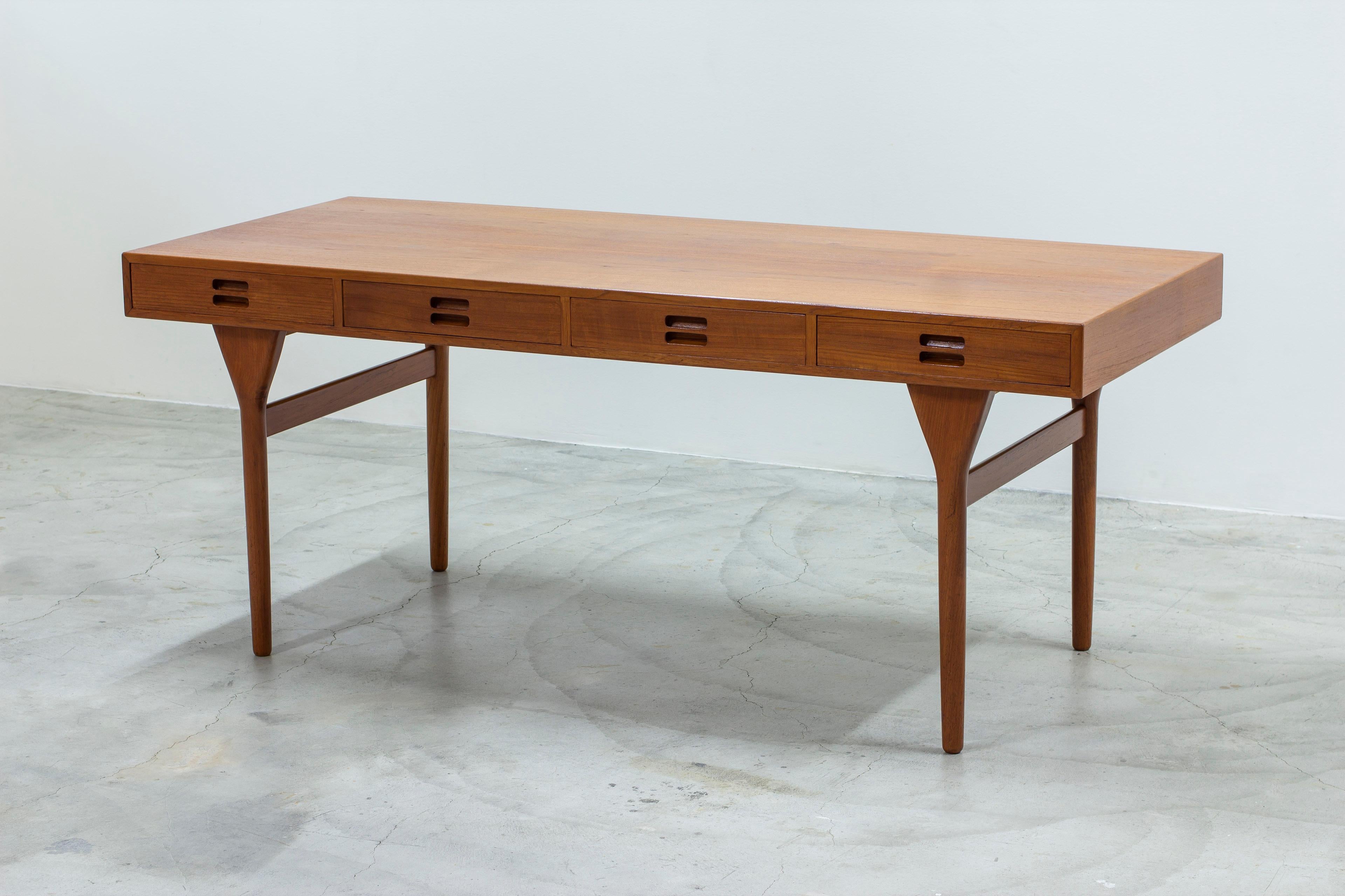 Escritorio icónico diseñado por Nanna Ditzel. Fabricado en Dinamarca por el ebanista Søren Willadsen. De cálida madera de teca con roble macizo en contraste en el interior de los cajones. Bonitas vetas de madera y bellos detalles. Patas en forma de