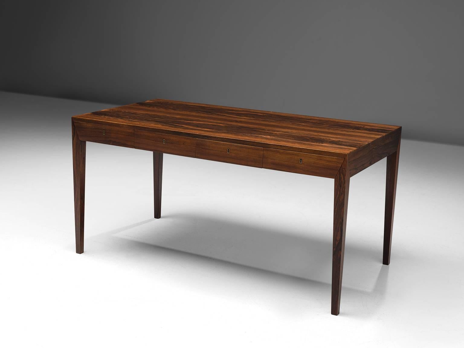 Desk by Severin Hansen Jr. for Haslev, Denmark, 1960s.

This elegant and simplified desk features four drawers. This writing table is executed in rosewood, showing wonderful craftsmanship.  Due the tapered high legs, the desk has an open and elegant