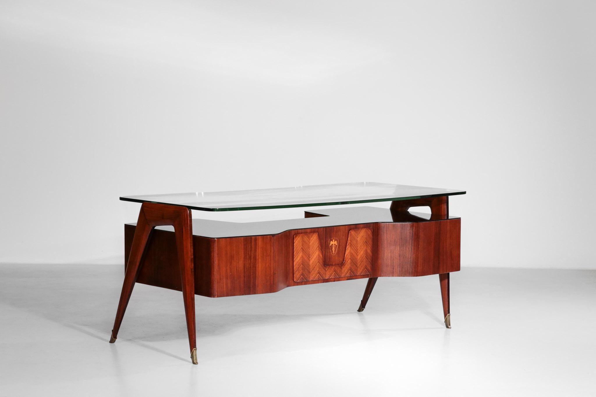Incredible desk by the famous designer Vittorio Dassi.
This desk has a thick glass on the top supported by a structure in walnut. Another glass in brown is situated on the top of the cases.
Nice marquetry and brass legs.
Many details and curb,