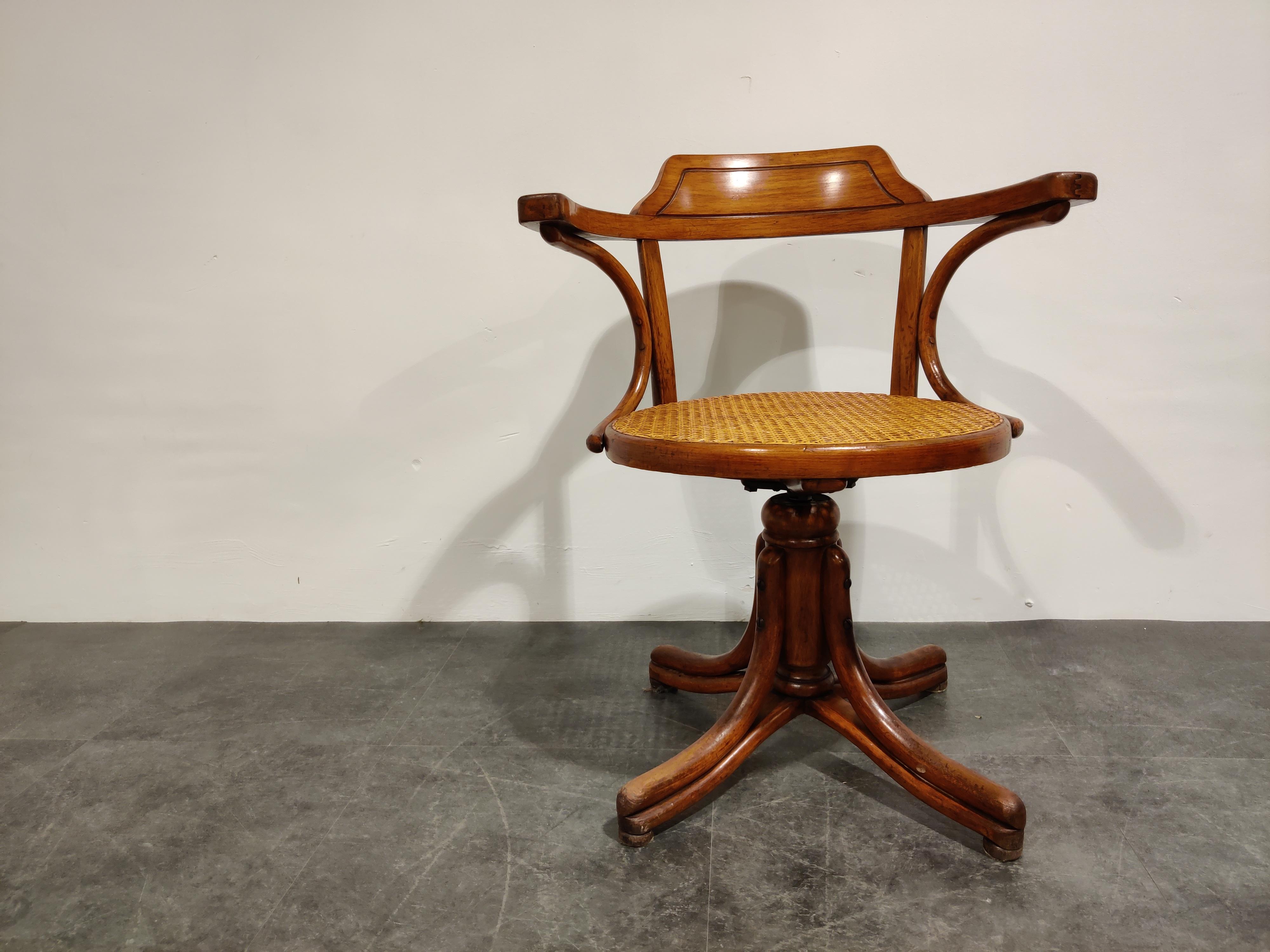 Vintage bentwood desk chair by Thonet with a rattan seat.

Beautiful piece with just the right wear.

This swivel chair is adjustable in height by turning it.

The seat has been refurbished in the past, so it's not the original rattan