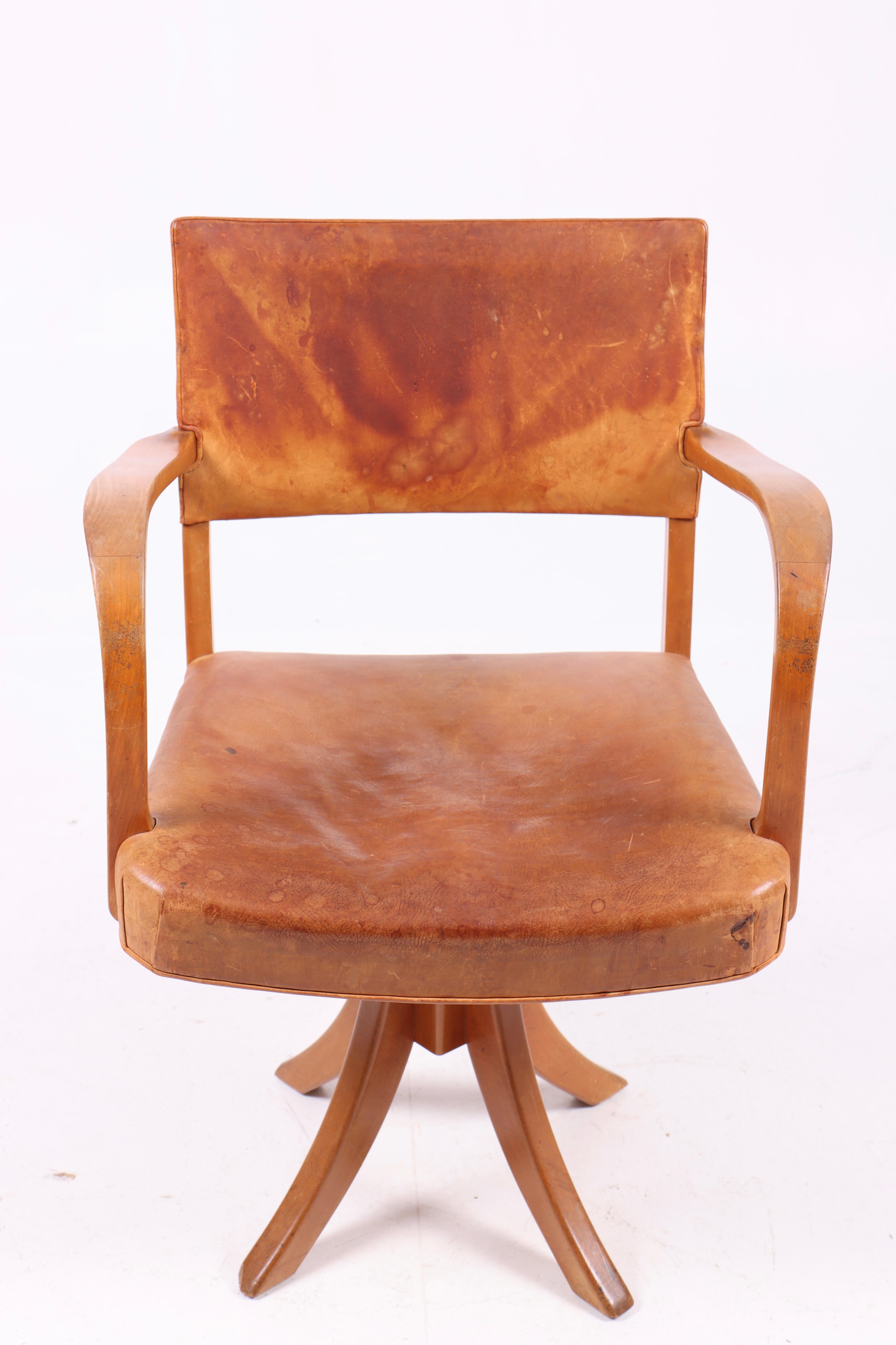 Swivel chair in patinated original leather. Designed and made in Denmark, great original condition.