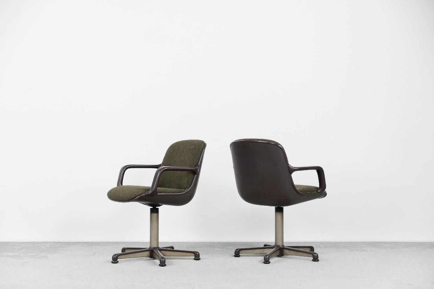 Cette paire de fauteuils de bureau a été conçue par Charles Pollock pour le fabricant allemand Comforto dans les années 70. Les sièges sont fabriqués en plastique brun durable et en tissu de haute qualité de couleur olive. Un pied pivotant ou des