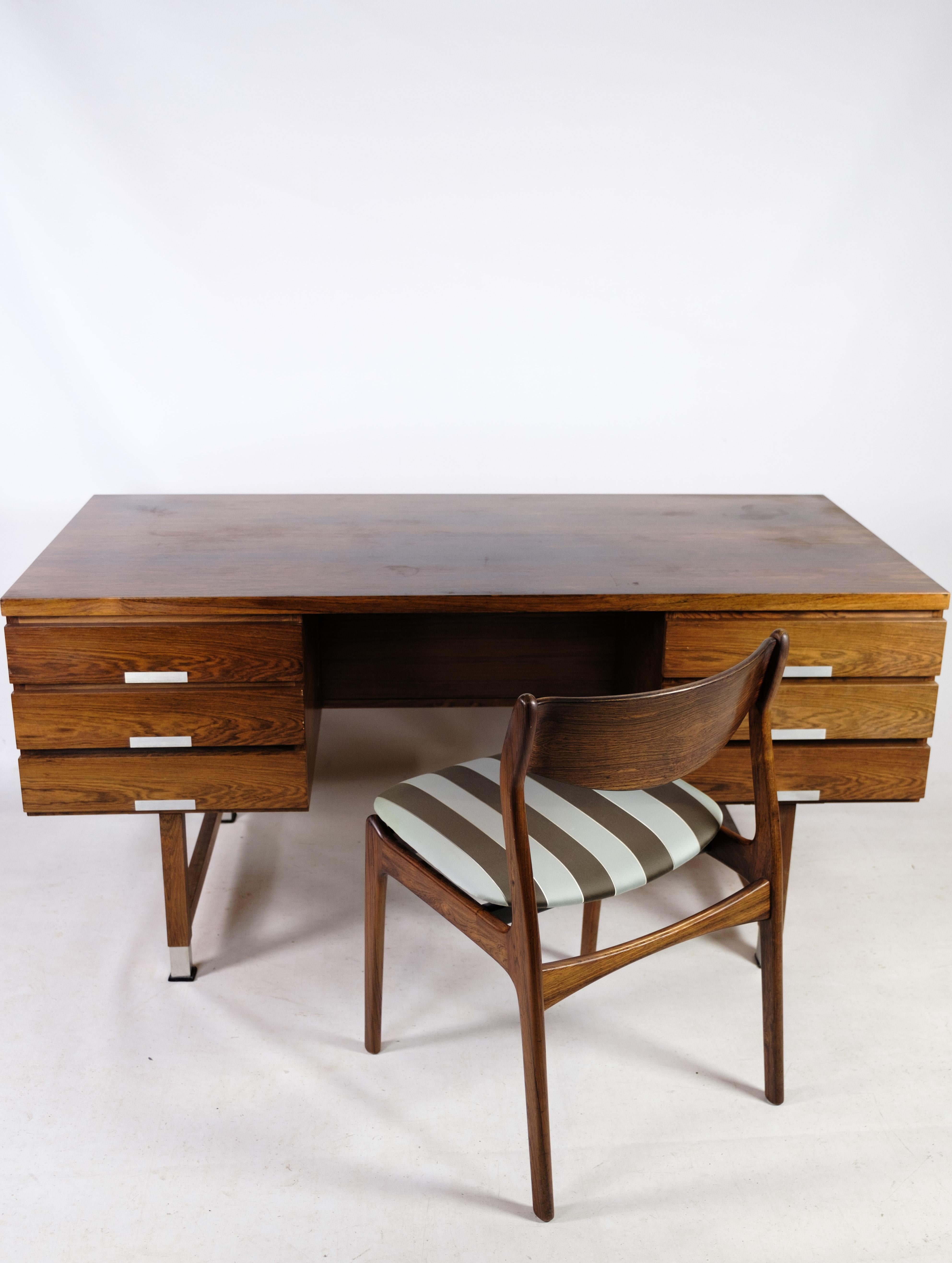 Desk, designed by Kai Kristiansen in rosewood from around the 1960s. The desk has six drawers on the front and divided open spaces on the back. Aluminum handle and shoes.