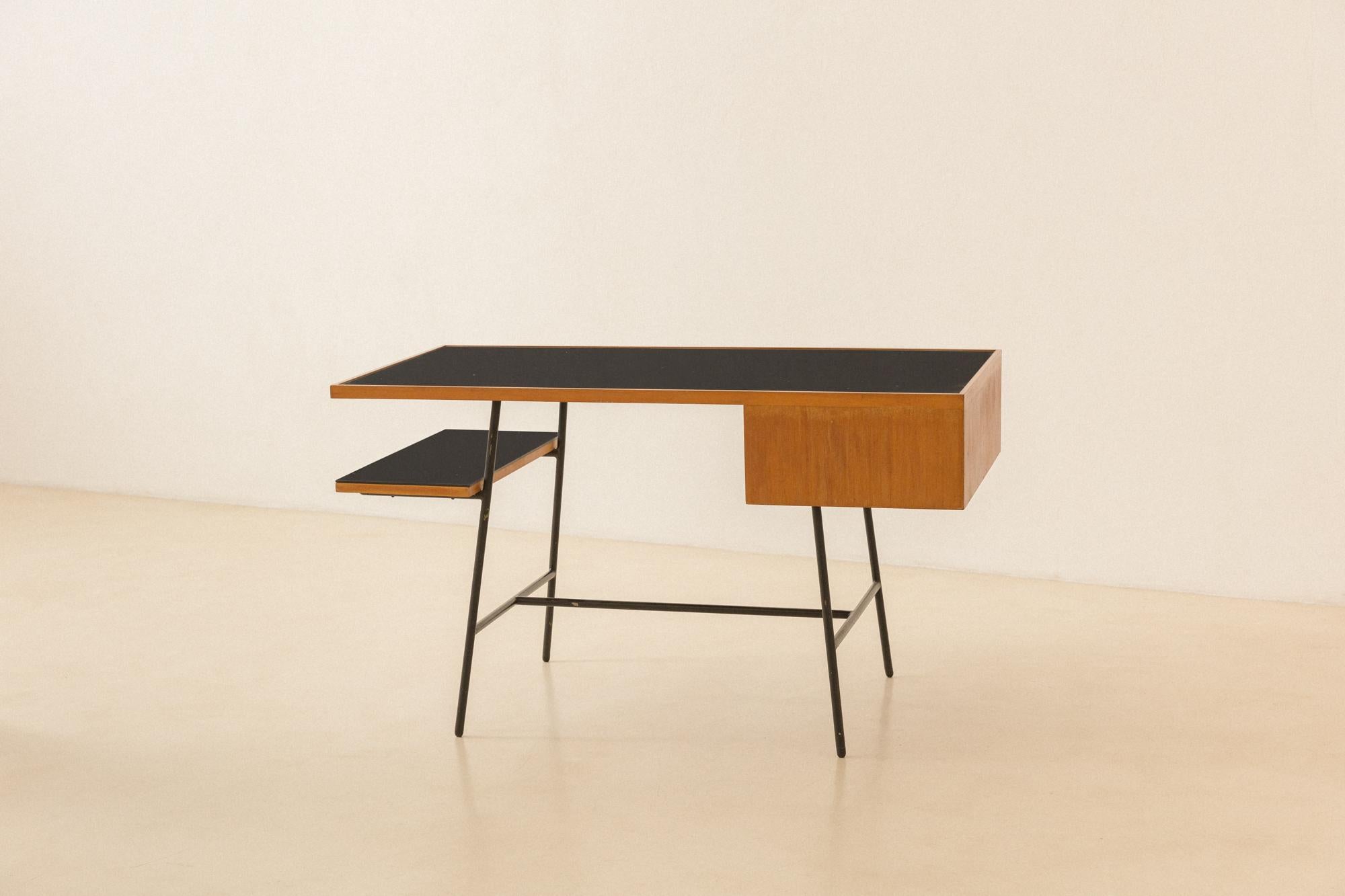 Este escritorio es una pieza rara y elegante diseñada por Carlo Hauner (1927-1997) y producida por Móveis Artesanal en la década de 1950. Presenta una encimera de madera de pau-marfim apoyada en pies de hierro, dos cajones en el lado izquierdo y una