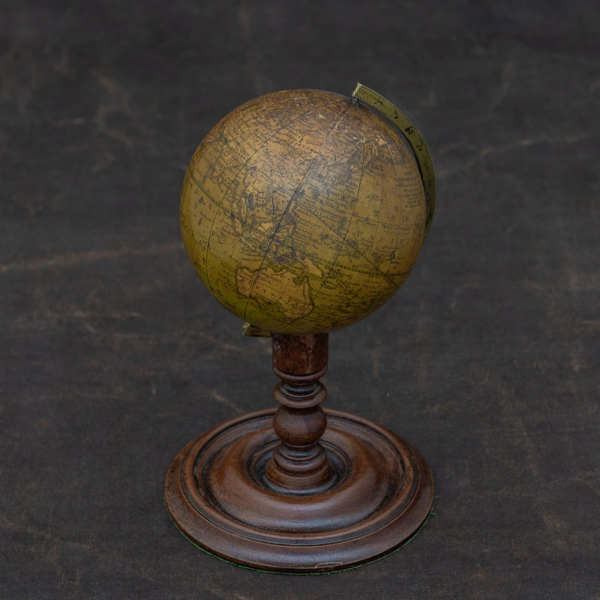 A handsome Smith's terrestrial globe, circa 1835. Mounted on a brass semi-meridian that sits on a turned wooden upright and circular base. Printed in several colours, the globe comprises of twelve paper gores over a 3½ inch sphere of gesso. The age