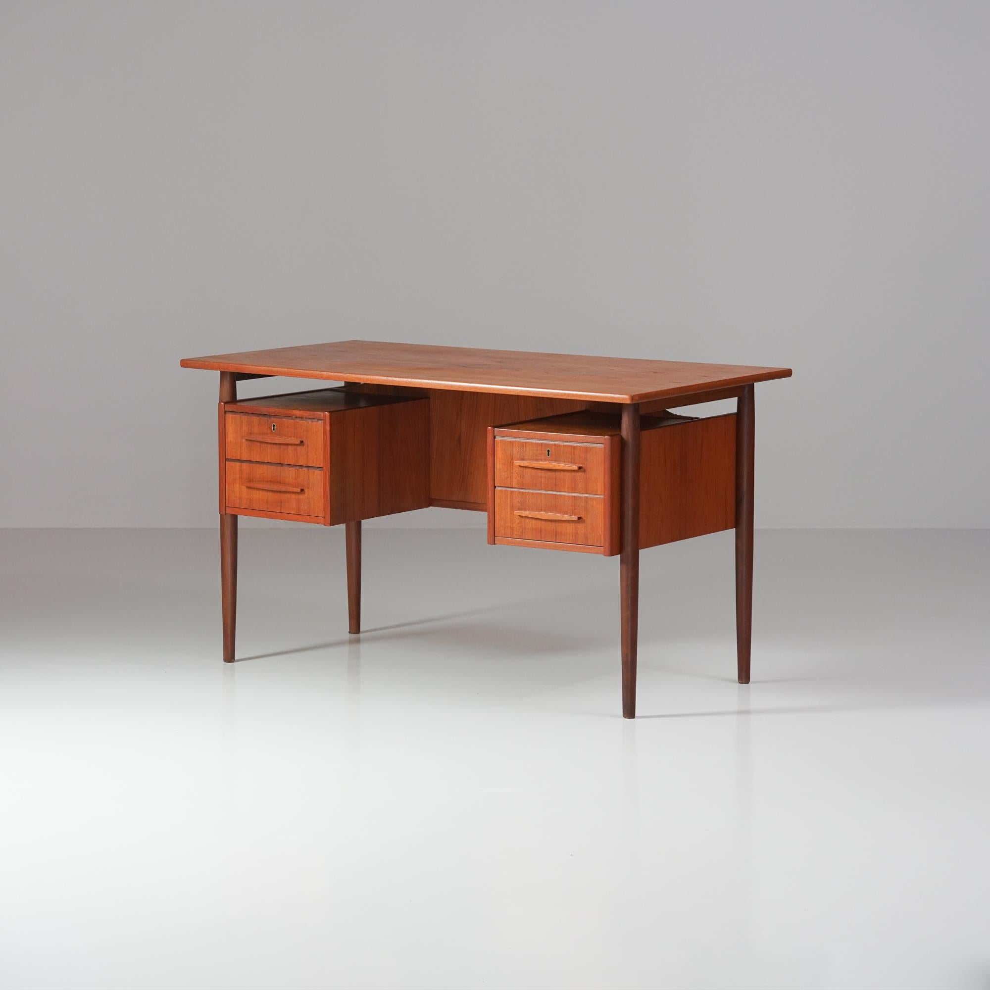 Scrivania, design di Gunnar Nielsen Tibergaard, Danimarca, anni 1950/1960. Teak. Quattro cassetti, libreria sul retro. Buone condizioni d'epoca, patina minore e usura coerente con l'età e l'uso. 