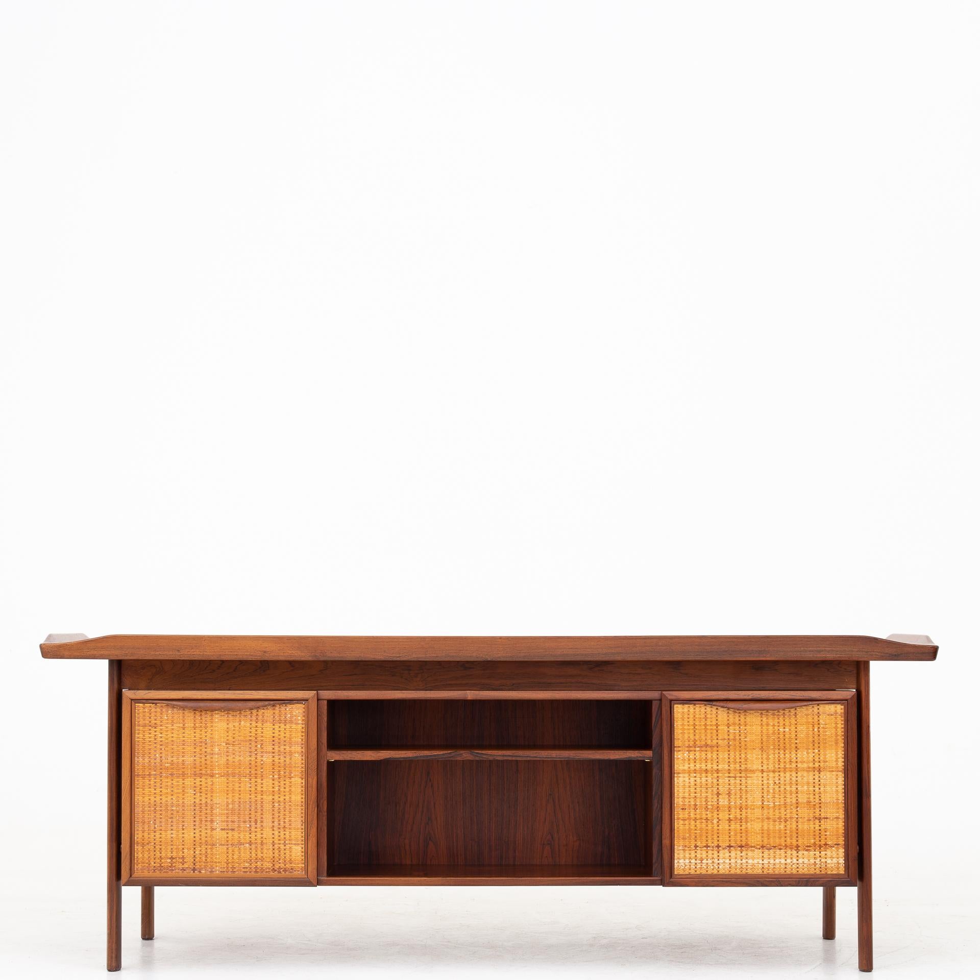 Desk in rosewood with cane doors. Unknown designer.