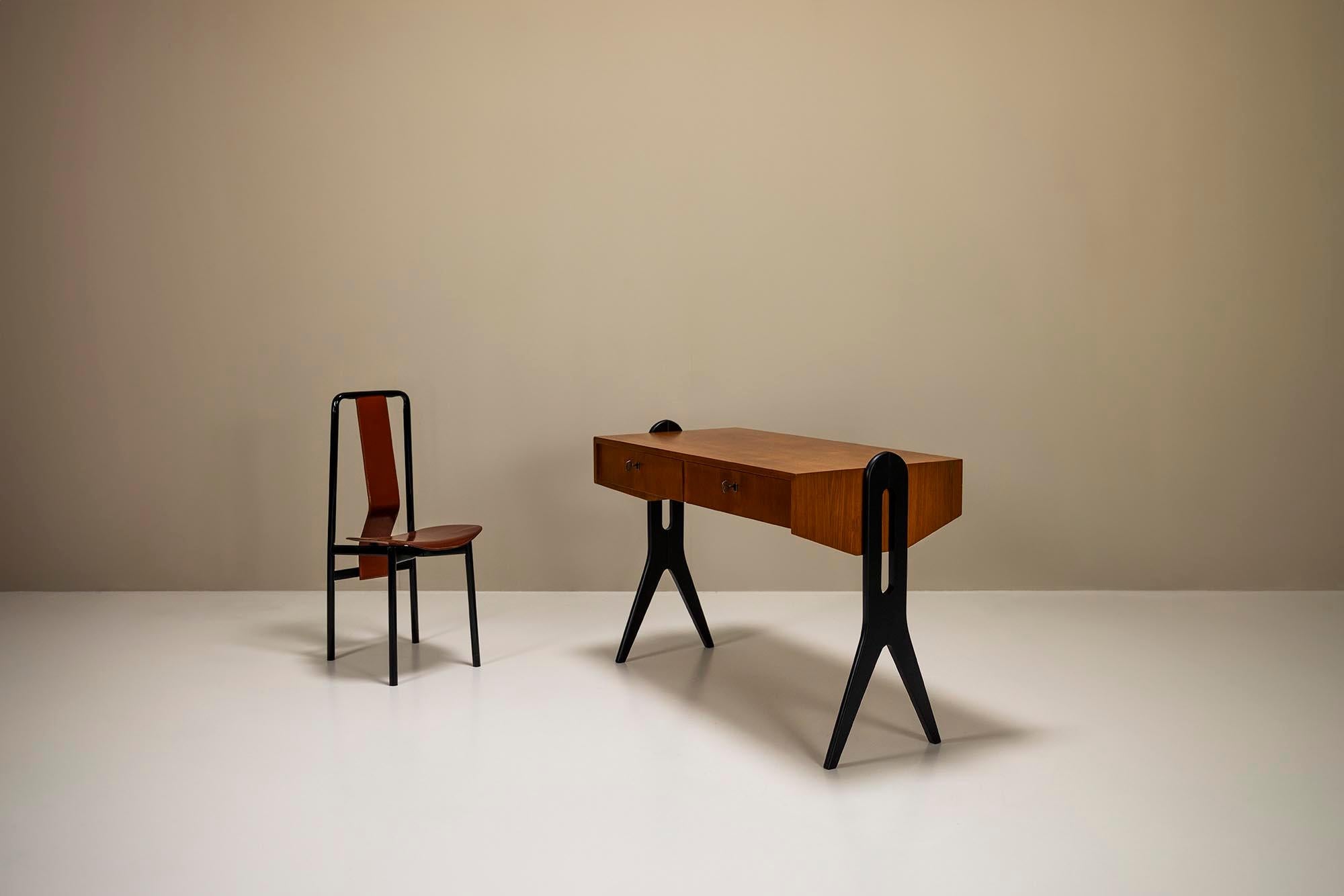 What immediately stands out about this desk are the black scissor-shaped legs that contrast sharply with the peculiar body part. We often see these heavily stylized legs in Italian design from the 1950s. For example, at the end of that era and the